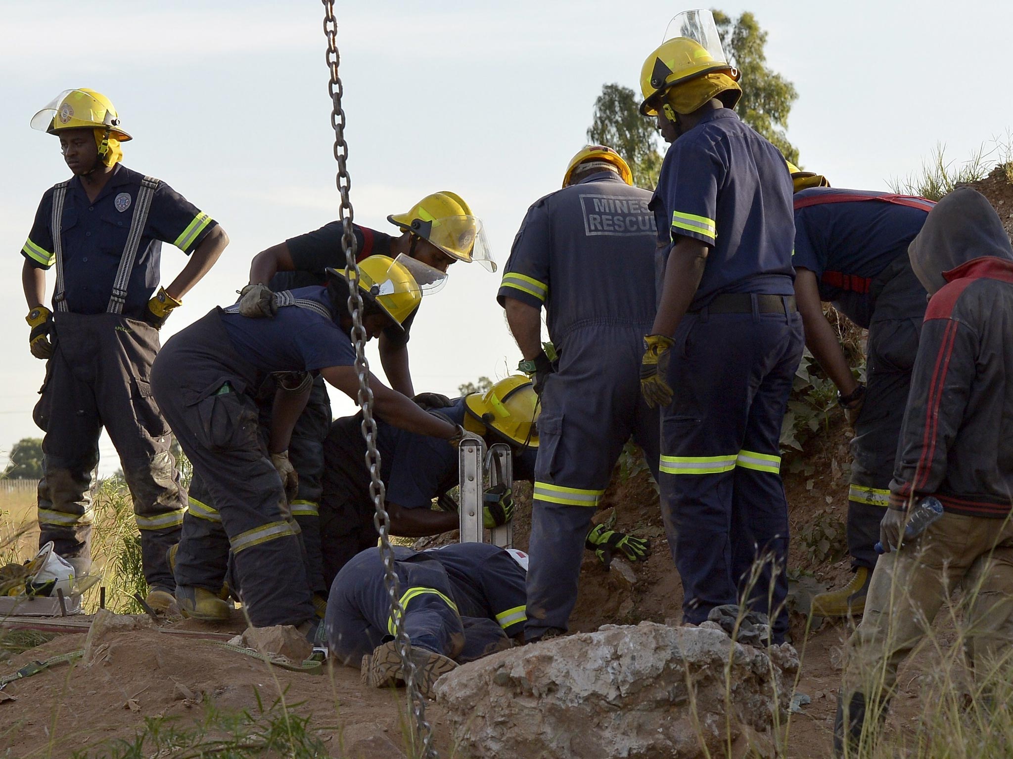 Rescuers pull out one of the workers who have been trapped in an illegal gold mine in Benoni