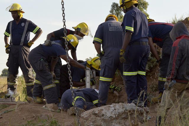 Rescuers pull out one of the workers who have been trapped in an illegal gold mine in Benoni