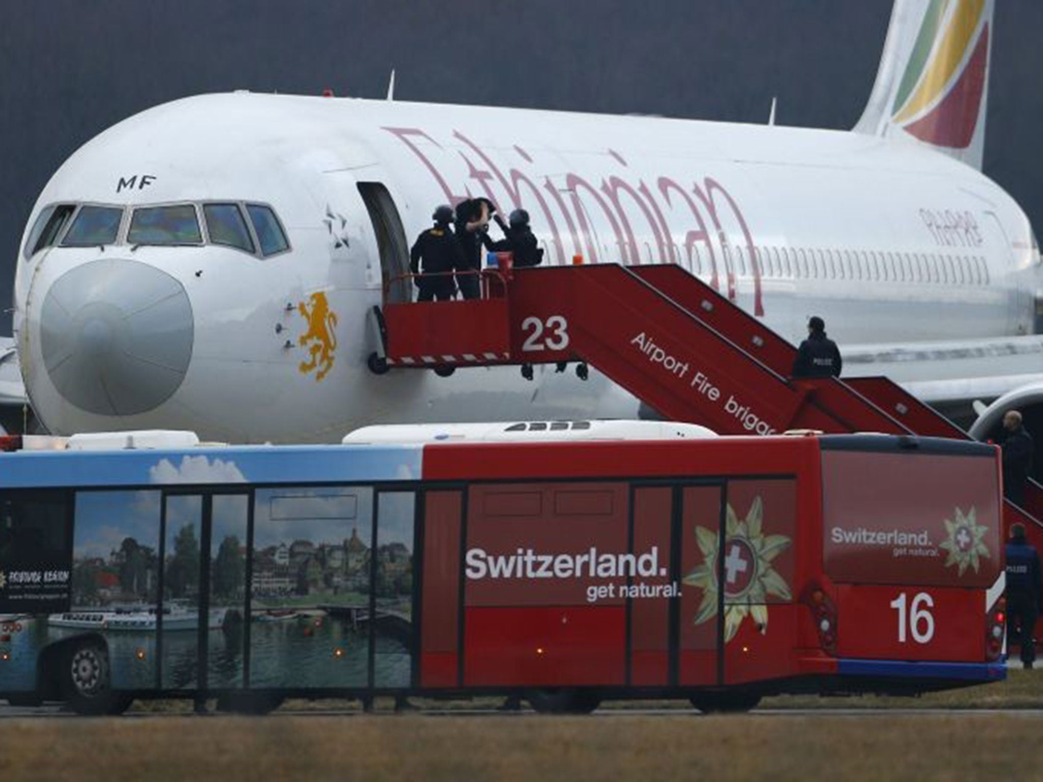 Police officers help a passenger disembark the hijacked Ethiopian Airlines flight ET 702