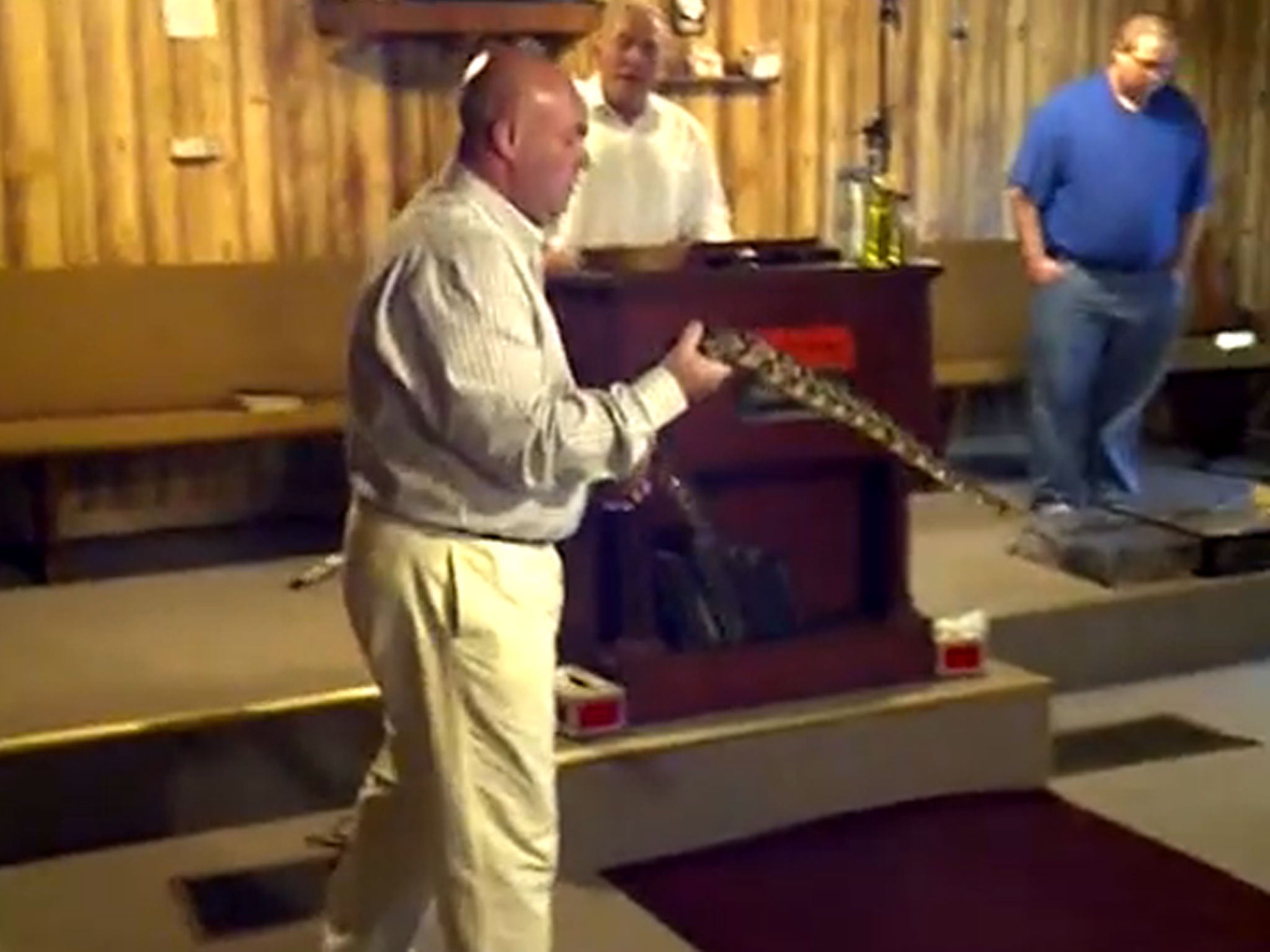 A still from a video showing Jamie Coots handling a snake during a service at Full Gospel Tabernacle In Jesus Name in Middlesboro, Kentucky