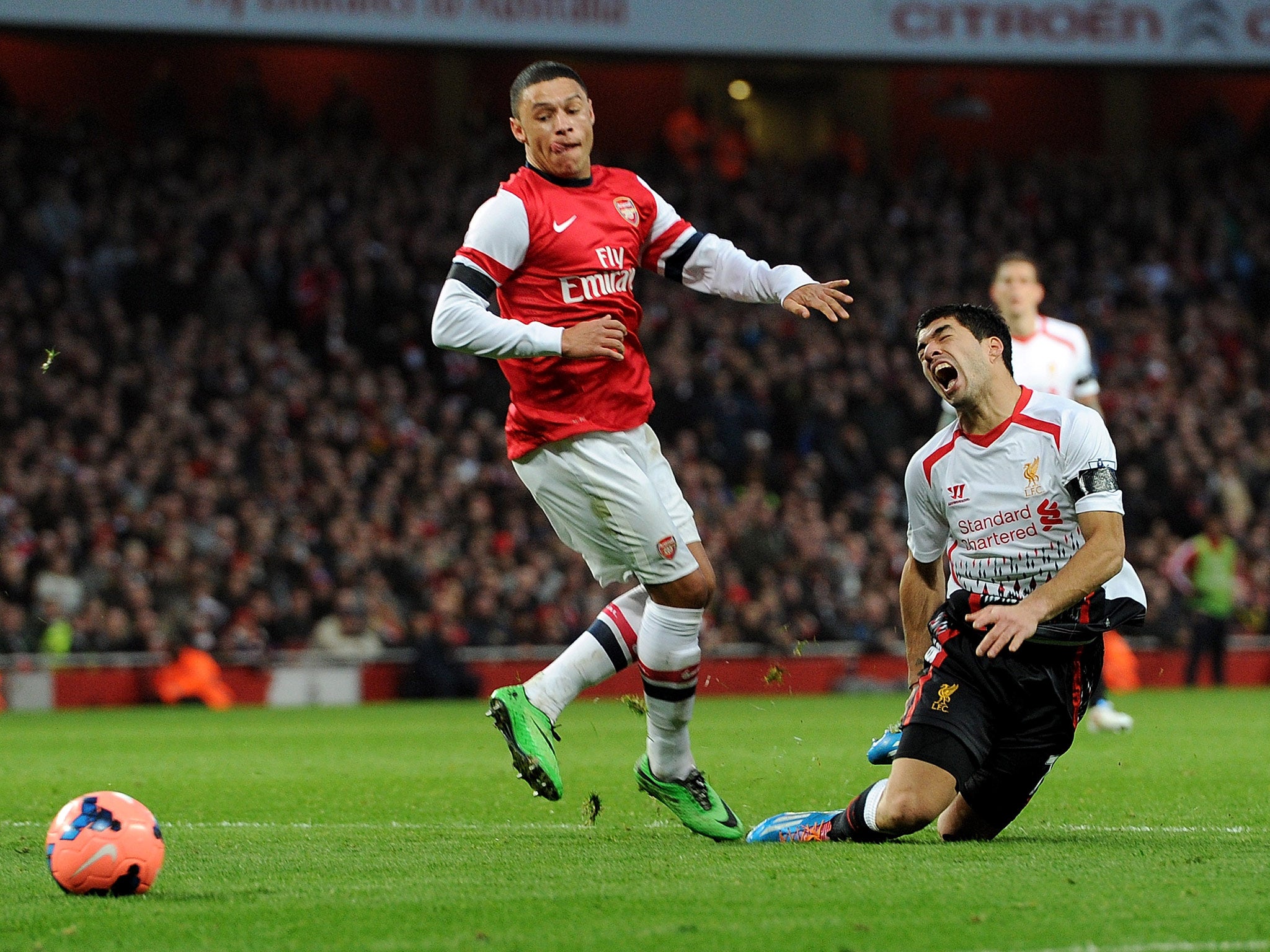 Luis Suarez of Liverpool is fouled in the box by Alex Oxlade-Chamberlain of Arsenal