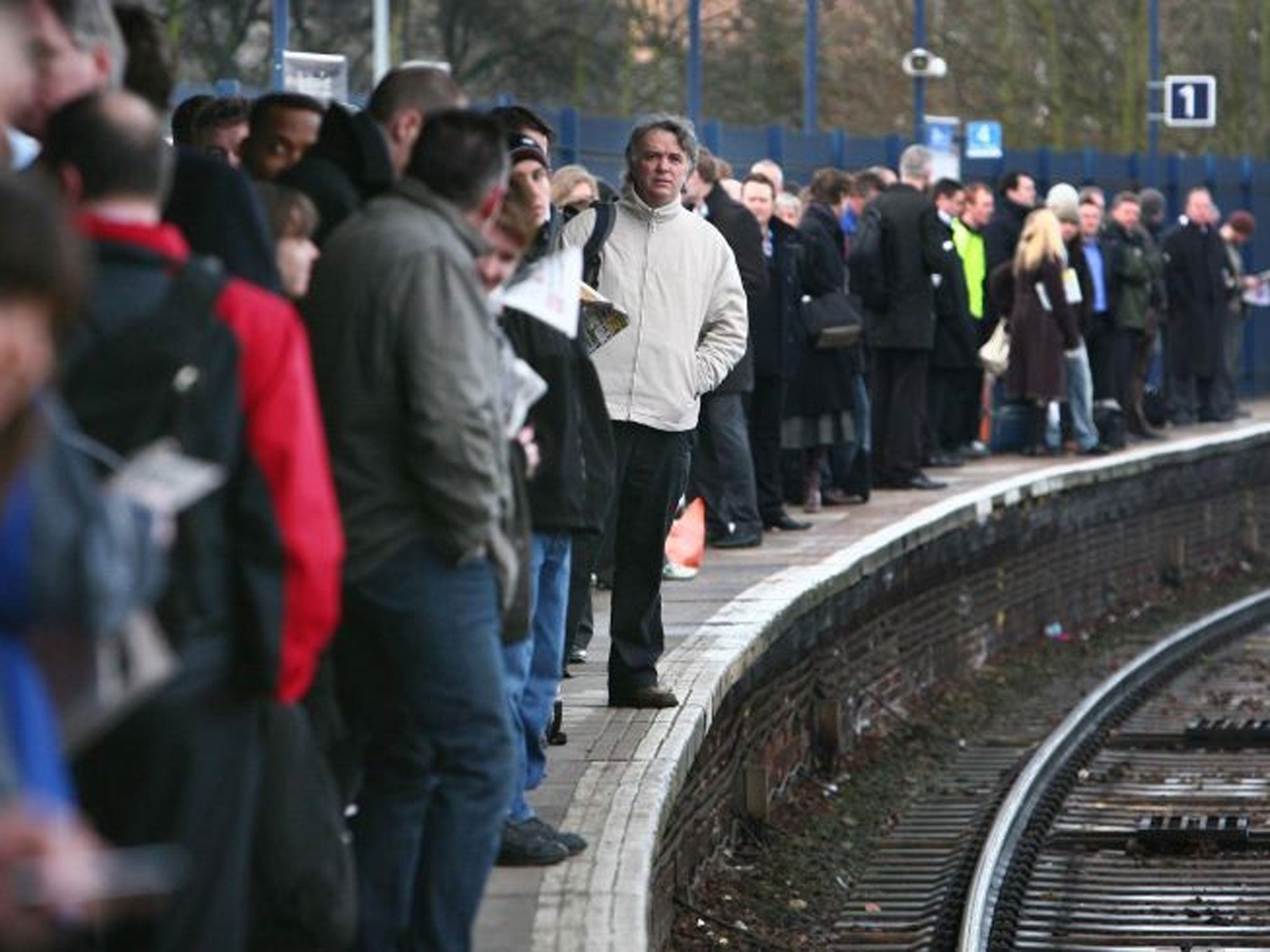 Commuters wait on a platform. Passenger satisfaction levels have dipped below 50% for the majority of train companies, according to a Which? survey of more than 7,000 regular travellers.