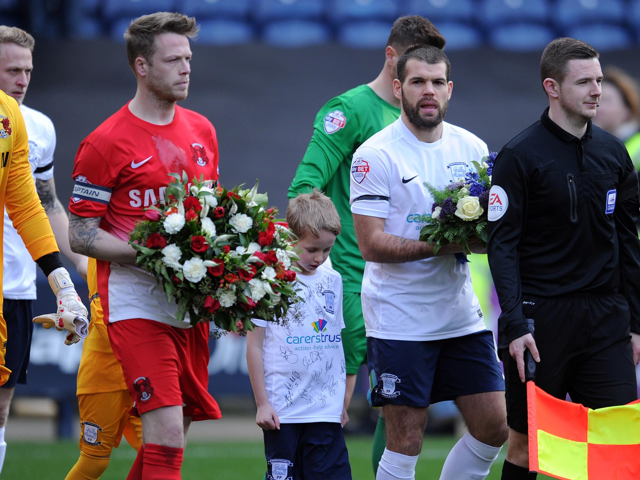 Captain, Nathan Clarke (left), carries flowers in tribute to Tom Finney
before Saturday’s game