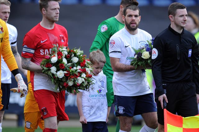 Captain, Nathan Clarke (left), carries flowers in tribute to Tom Finney
before Saturday’s game