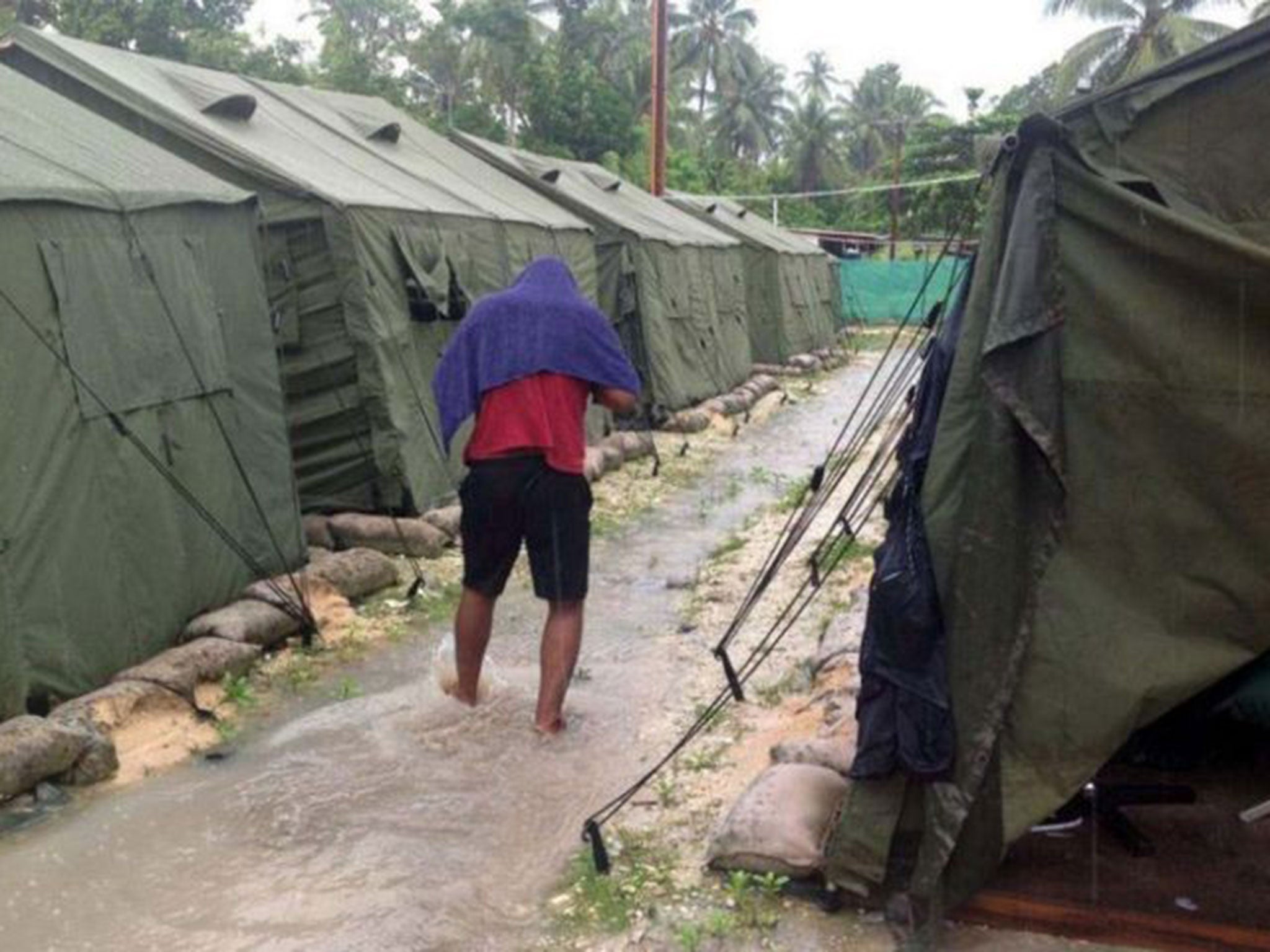 A man walks between tents at Australia's regional processing centre on Manus Island, where one inmate died in riots today