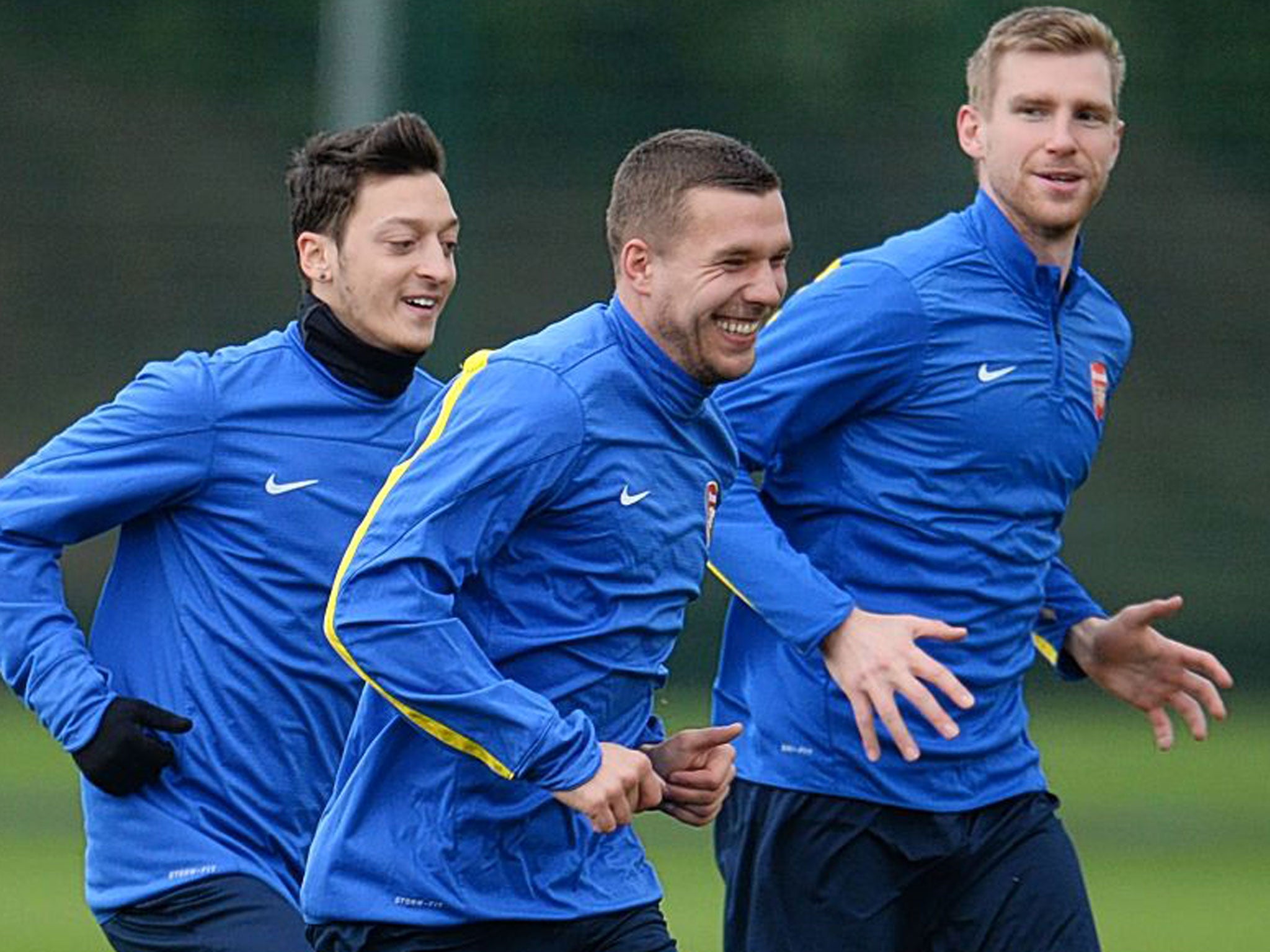 Arsenal’s German contingent of (left to right) Mesut Özil, Lukas Podolski and Per Mertesacker share a joke in training yesterda