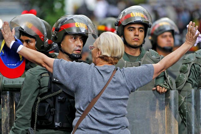 An opposition supporter shouts at a riot police officer during a protest against President Nicolas Maduro's government in Caracas 