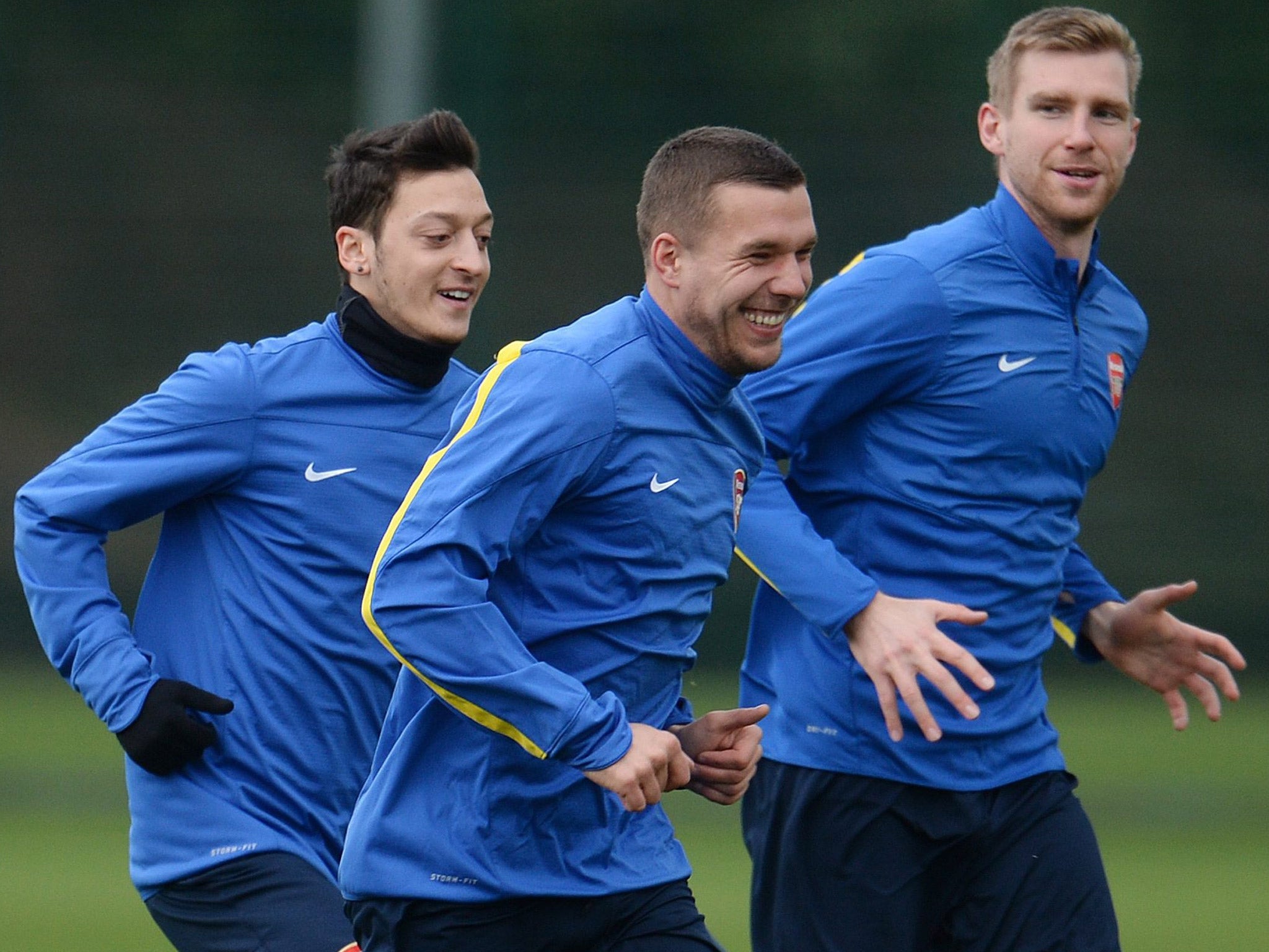Arsenal’s German contingent of (left to right) Mesut Özil, Lukas Podolski and Per Mertesacker share a joke in training