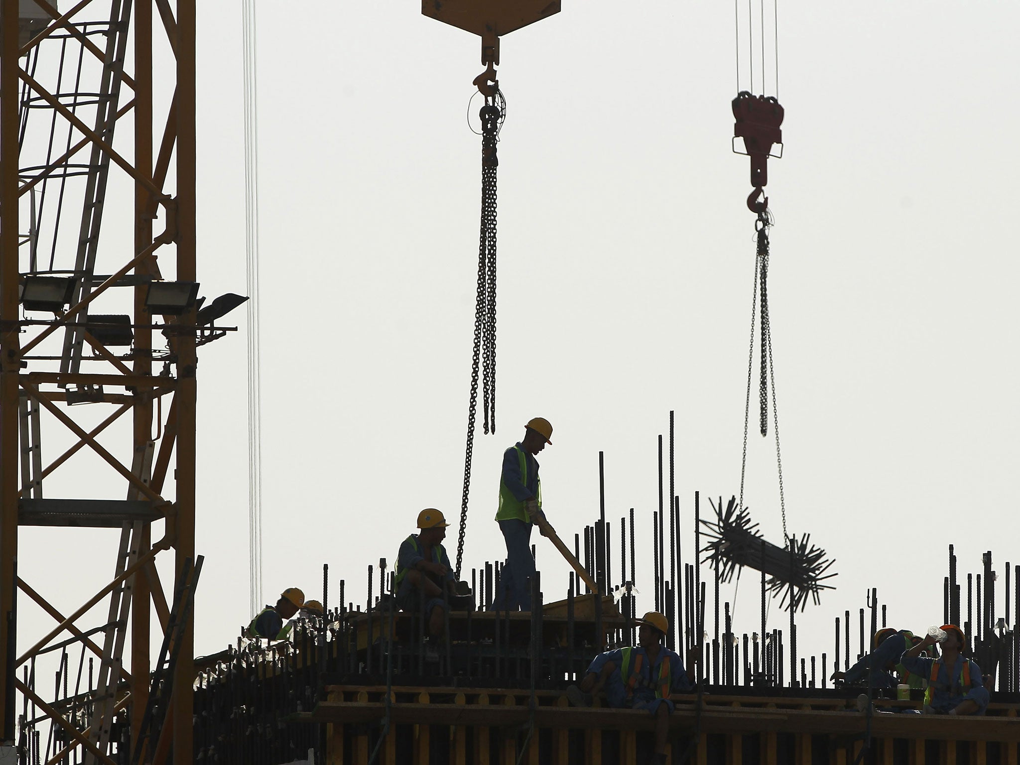 Workers, unrelated to the World Cup, stand on the construction site in Qatar. 
