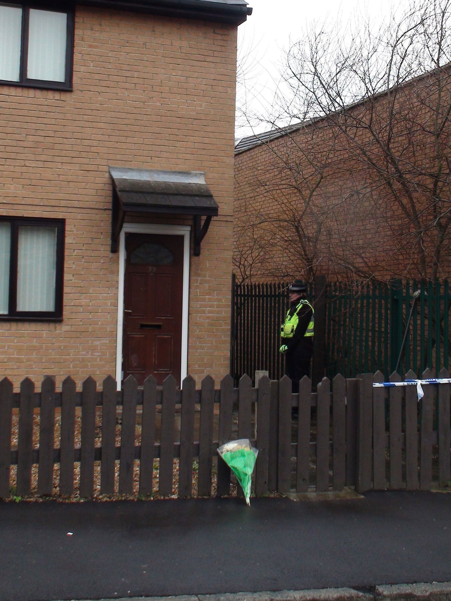 A police woman stands outside a house on Delamere Street, Bradford, following reports that a woman and child had been found unconscious outside the back of the house.