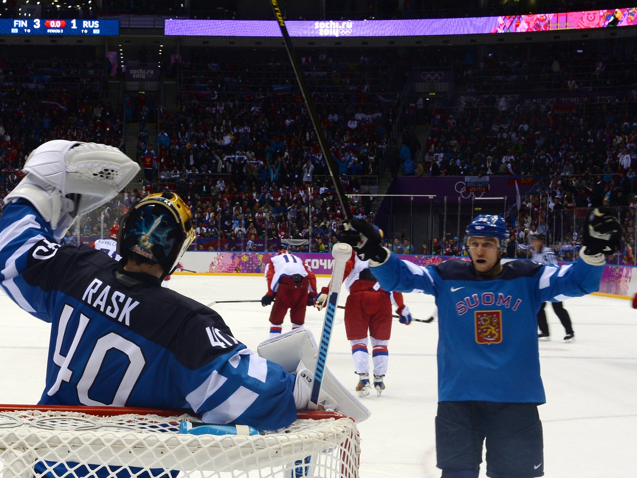 Finland's goalkeeper Tuukka Rask (L) celebrates with a team-mate at the end of the Men's Ice Hockey play-off quarter-final against Russia, which they won 3-1