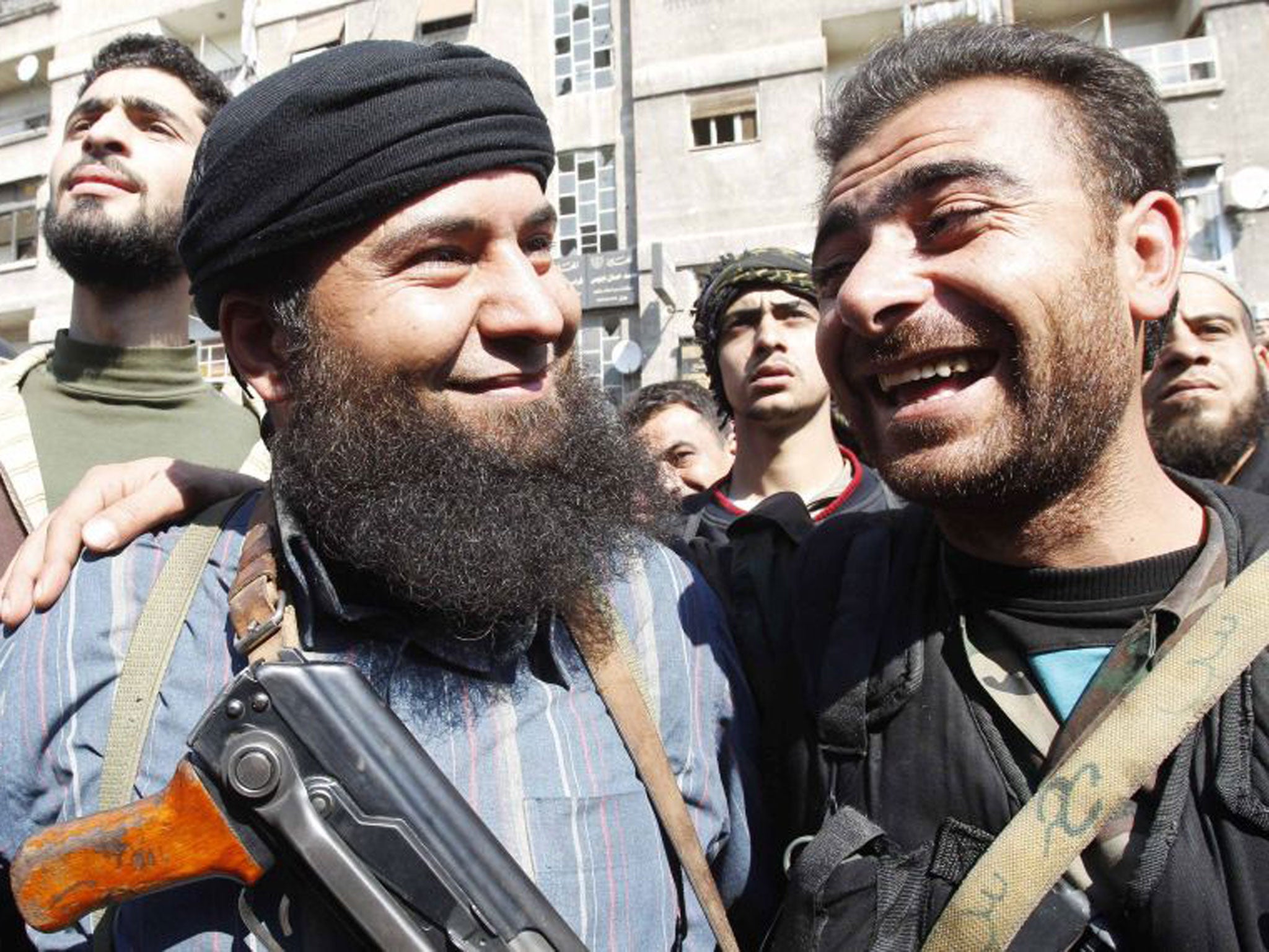 A soldier loyal to Syria's President Bashar al-Assad, right, jokes with a member of Syria's armed opposition forces in Babbila town