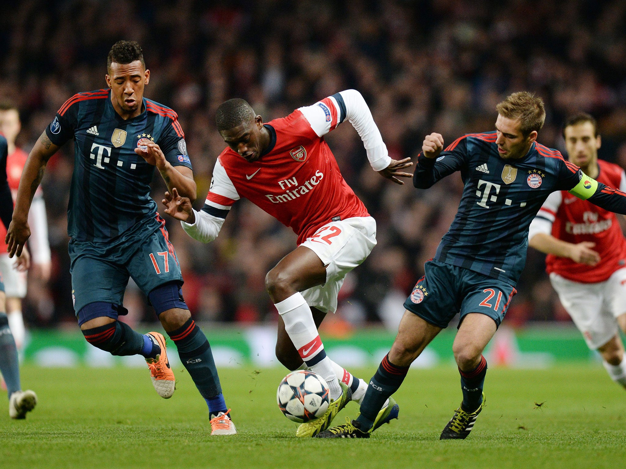Arsenal's Yaya Sanogo, centre, vies for the ball with Bayern Munich's Philipp Lahm, right and team mate Jerome Boateng, left