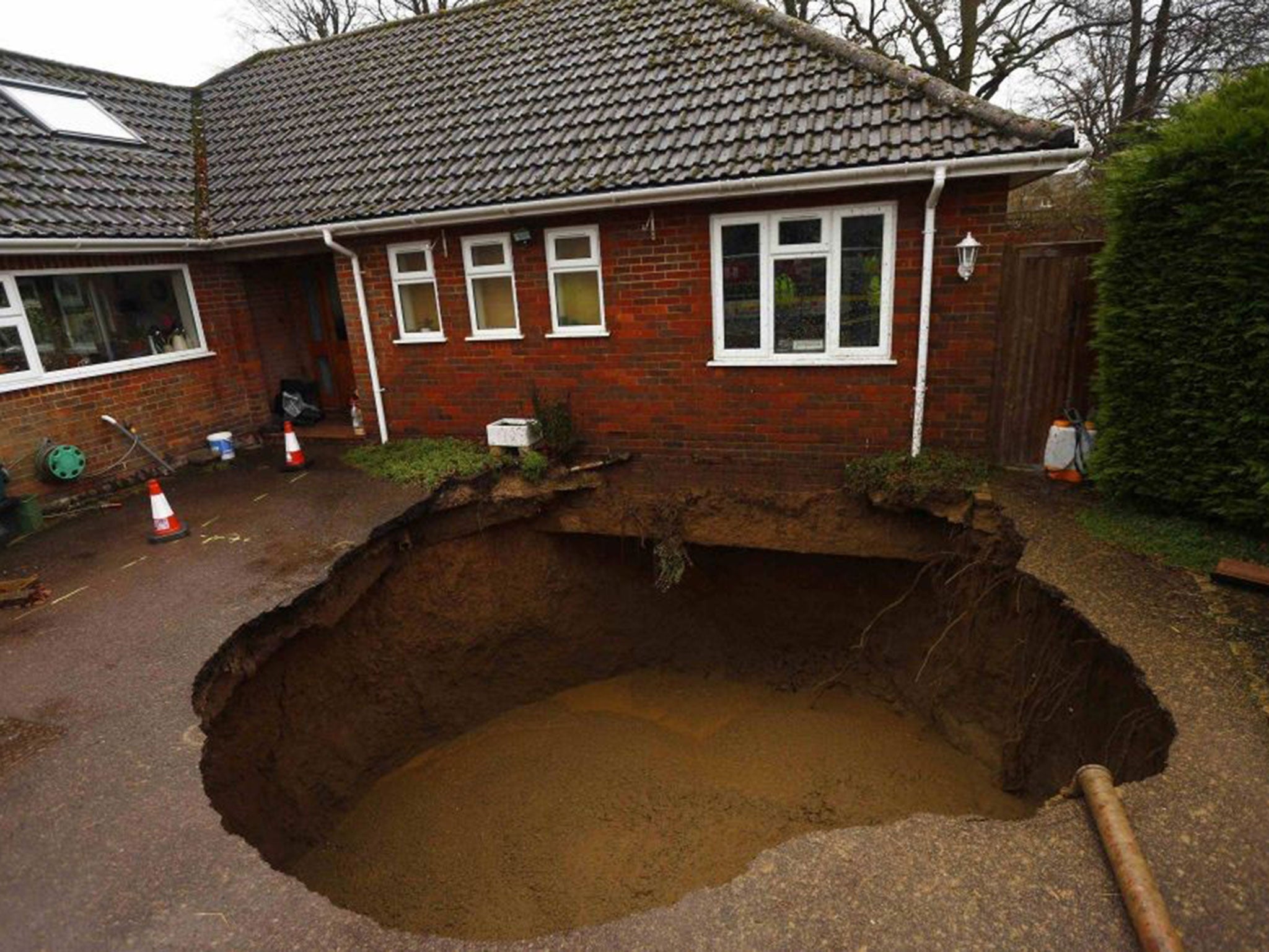 The 15-ft sinkhole in Walters Ash, Buckinghamshire, is being filled with concrete