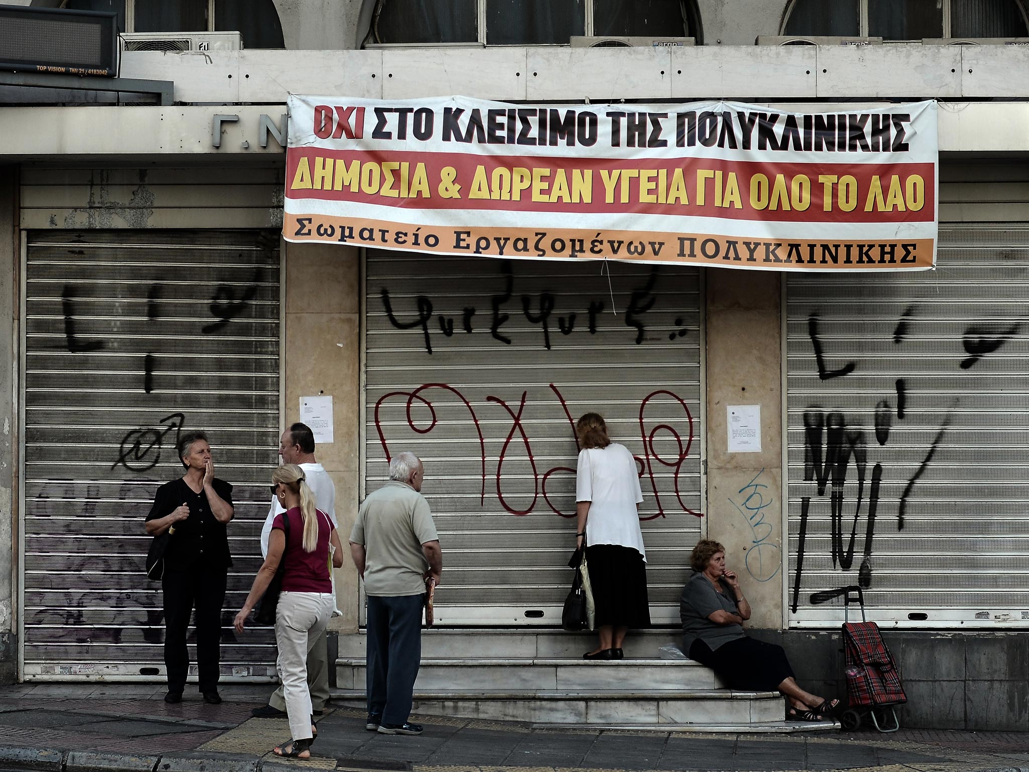 People stand outside the "Polyklikini", one of the hospitals affected by overhaul of the health sector