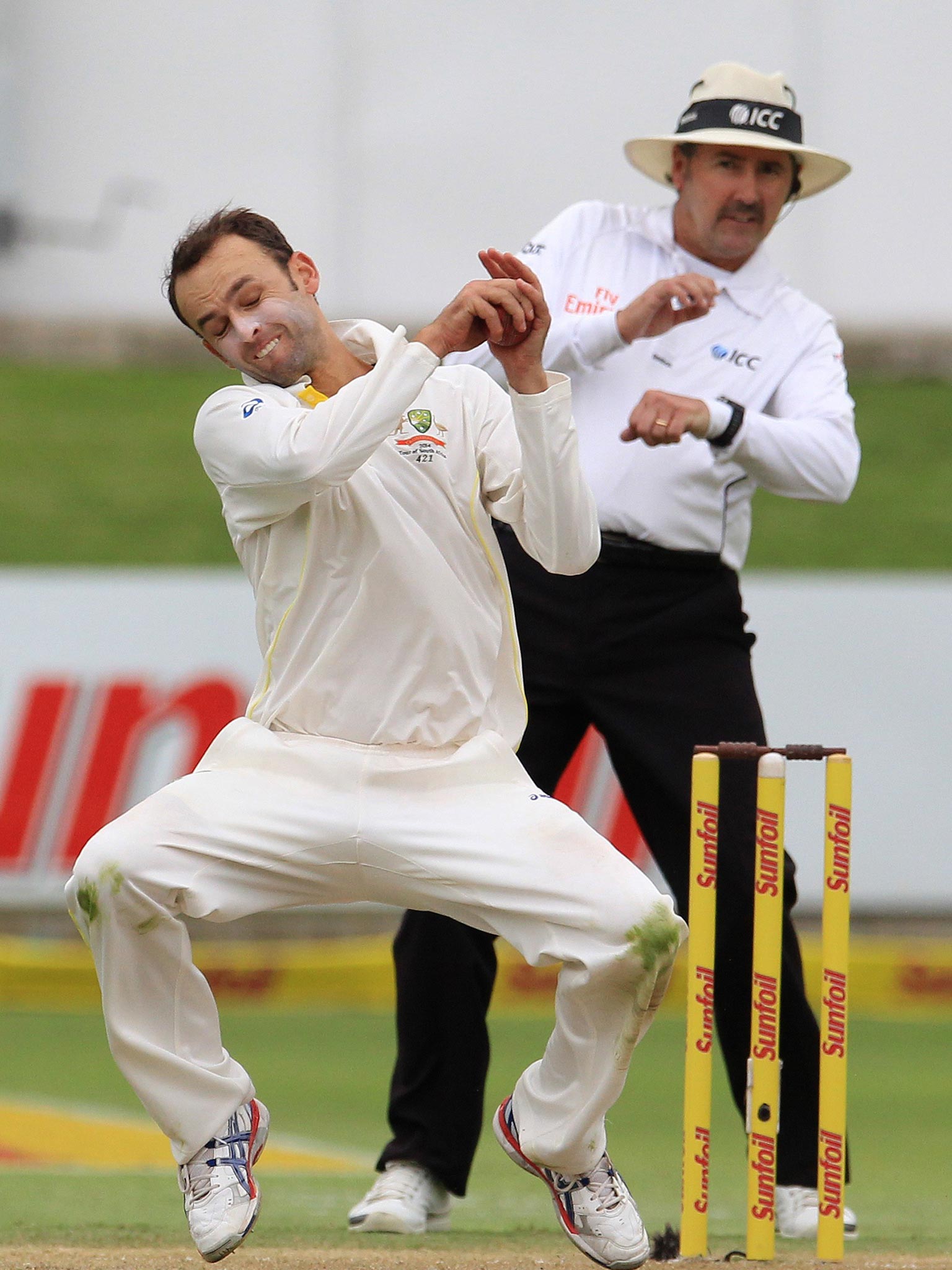 Australia spinner Nathan Lyon fields the ball from his own bowling as umpire Richard Illingworth prepares for evasive action in the background
