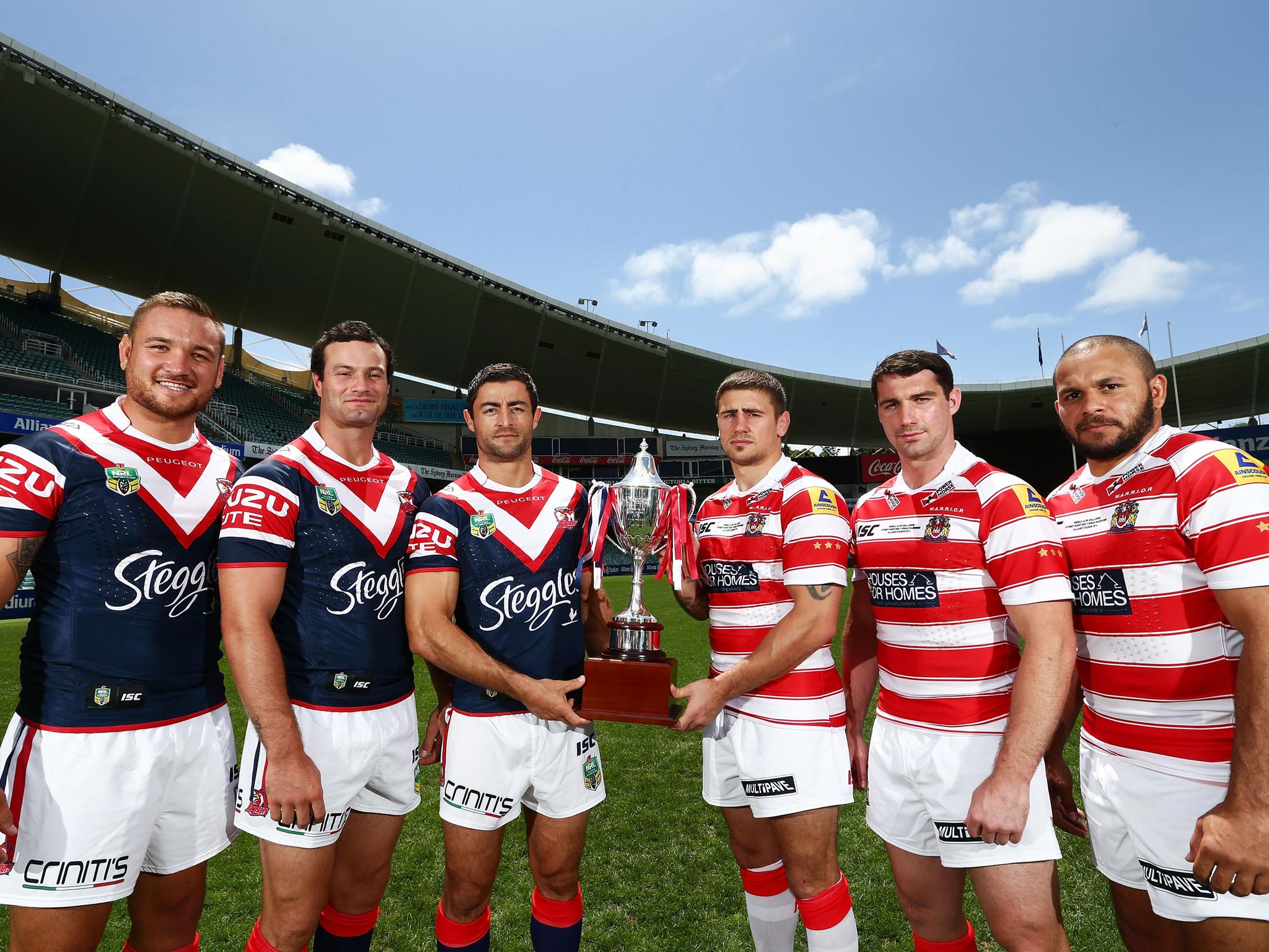 Sydney Roosters and Wigan Warriors players pose with the World Club Challenge trophy at the Allianz Stadium in Sydney