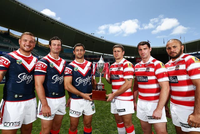 Sydney Roosters and Wigan Warriors players pose with the World Club Challenge trophy at the Allianz Stadium in Sydney