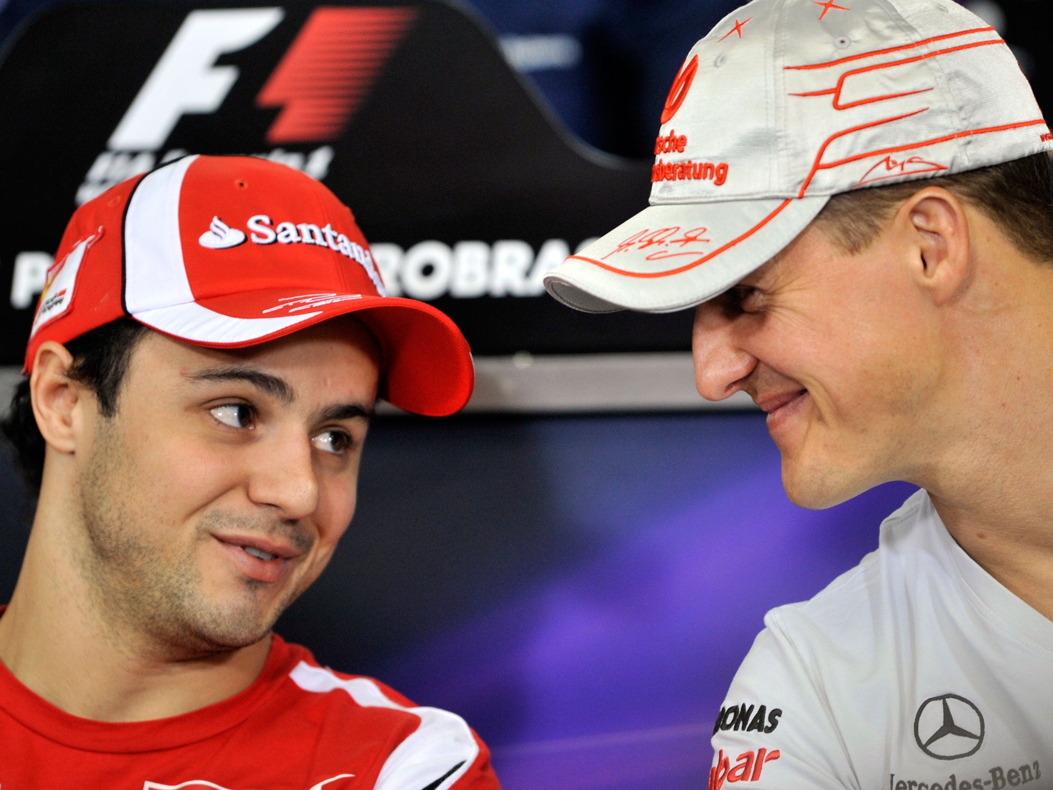 Felipe Massa and Michael Schumacher share a joke at the 2011 Brazilian Grand Prix