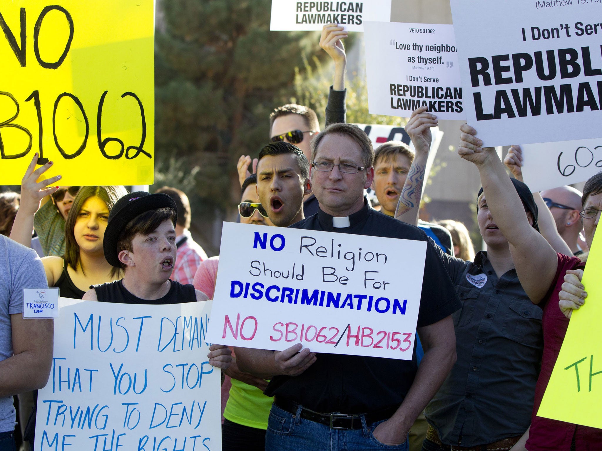 Opponents of the SB1062, a religious freedom bill, Ryan Ebersole, of Mesa, and Rev. Stephen Govett, of Glendale, urged Gov. Brewer to veto the bill during a protest rally Friday, Feb. 21, 2014, at the state Capitol