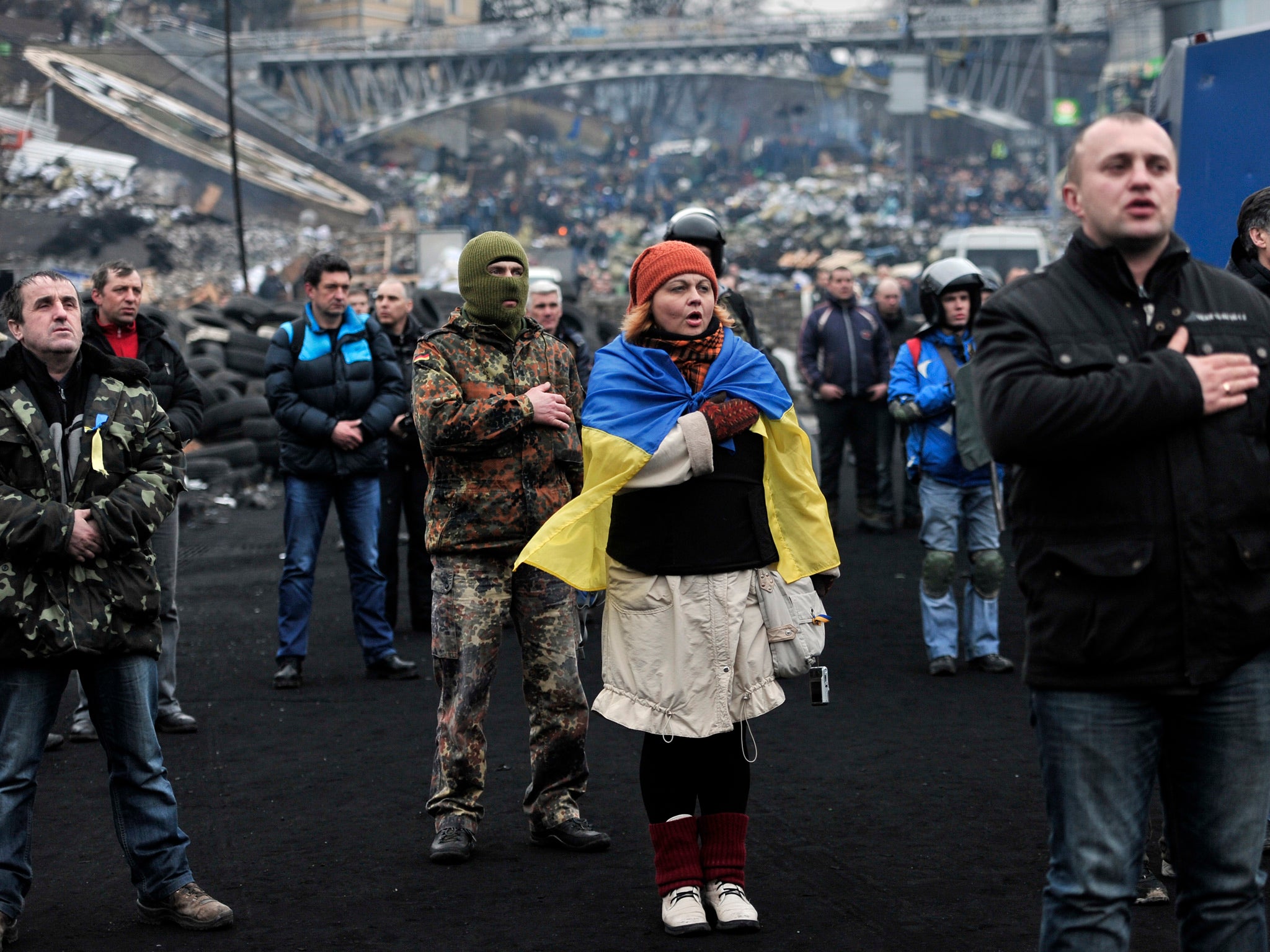 Anti-government protesters sing the Ukrainian national anthem at the Independence square in central Kiev on 22 February