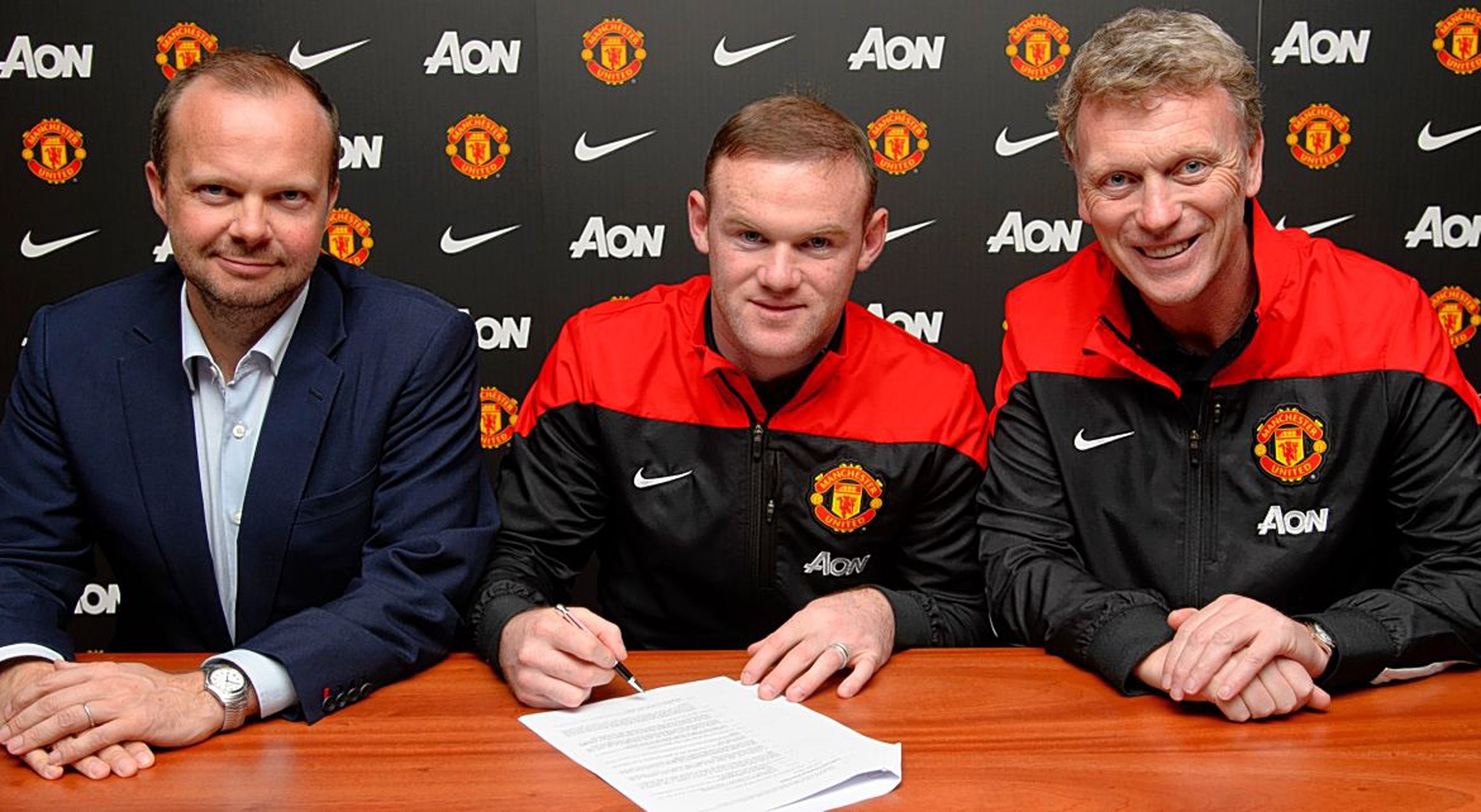 Bad sign: Wayne Rooney commits his future to United watched by David Moyes (right) and CEO Ed Woodward