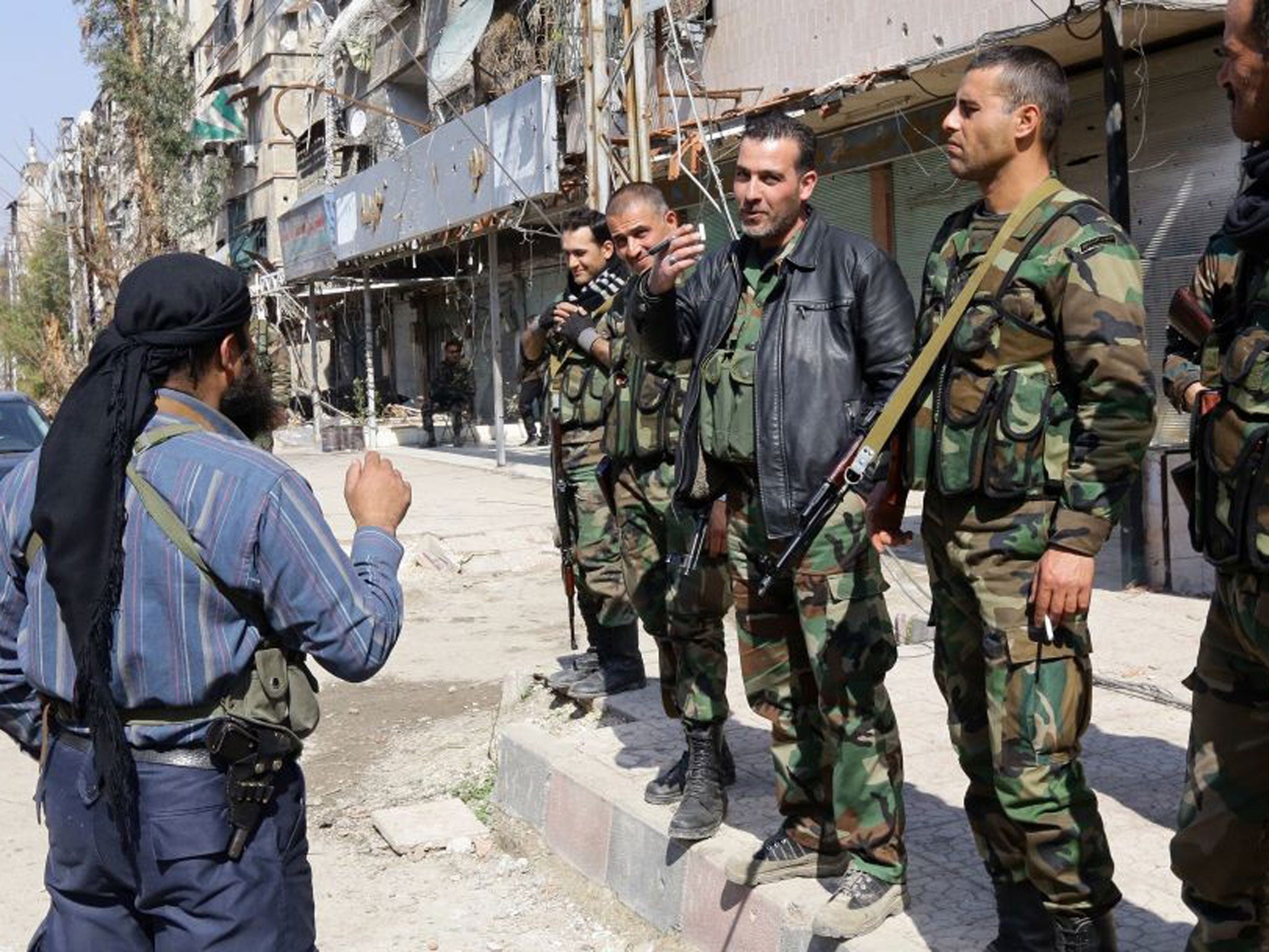 Time to talk: Pro-regime fighters speak to a rebel during a truce in Babbila, a Damascus suburb, earlier this month