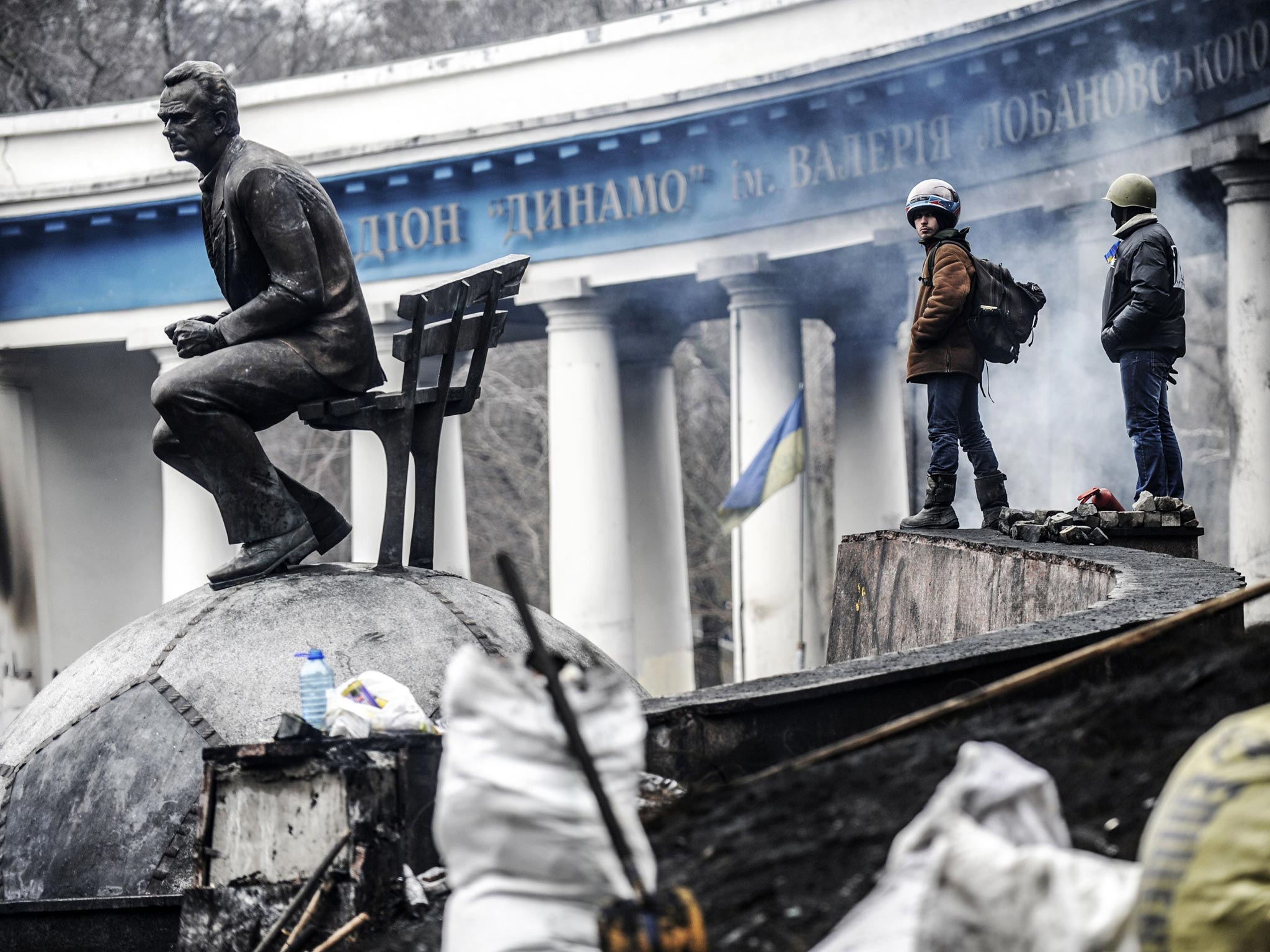 Anti-government protesters stand on a barricade at the entrance of Kiev's Independence square 