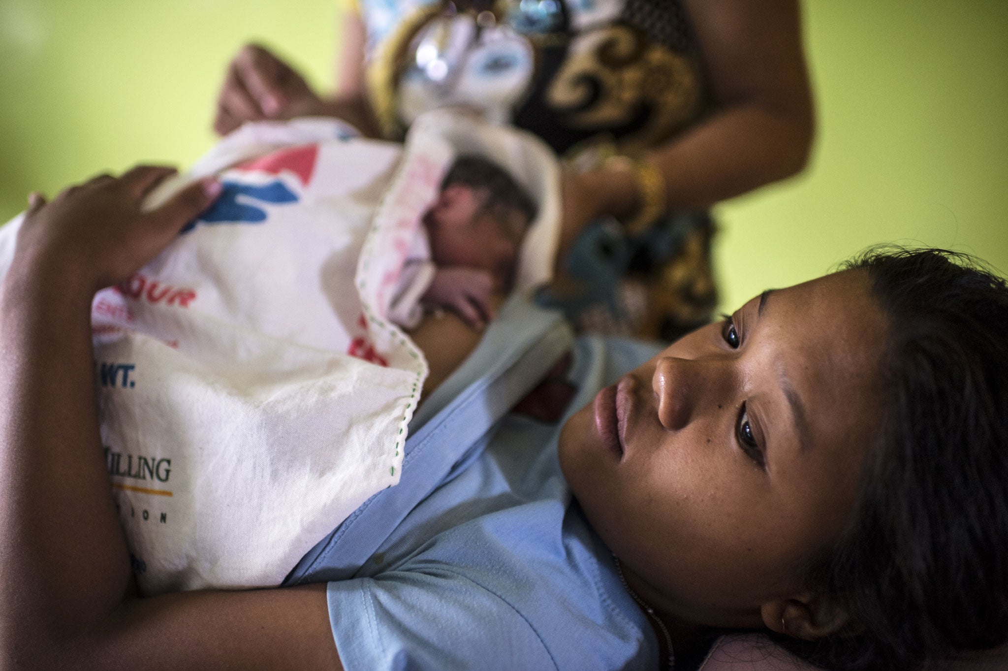 Analyn feeds her newborn baby in the rural health unit in Tolosa, outside of Tacloban