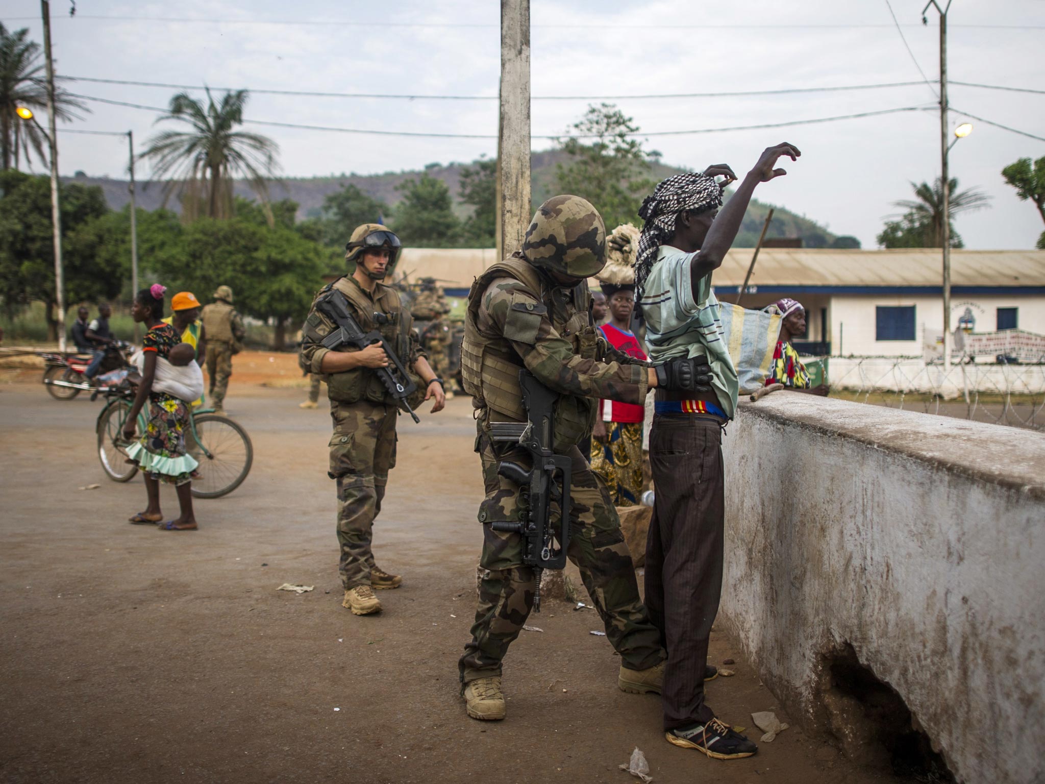 A French soldier frisks a man at a checkpoint in the PK12 district in
Bangui, as Operation Sangaris continues