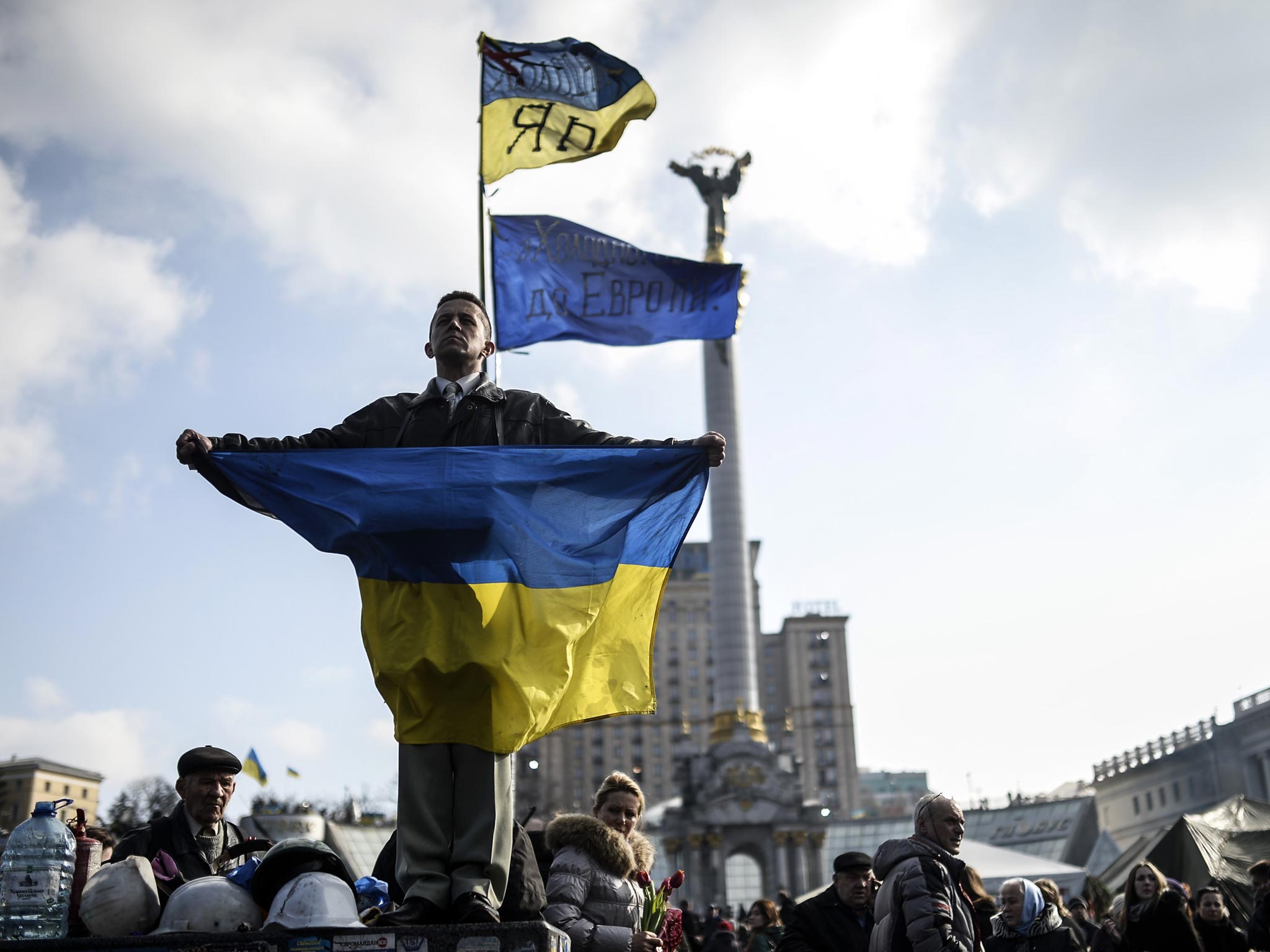 A protester wraps himself in the Ukraine flag in Kiev yesterday