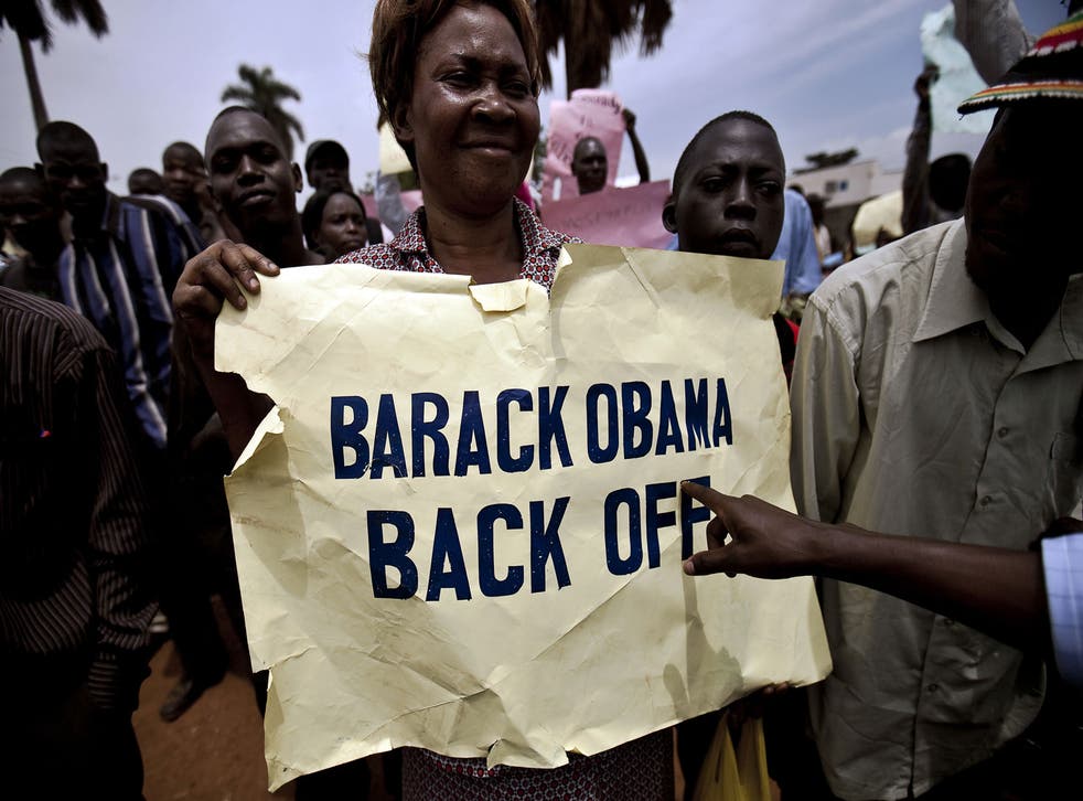 Photo made on February 14, 2010 shows a woman holding a placard as she takes part in an anti-gay demonstration in Jinja, Kampala. 