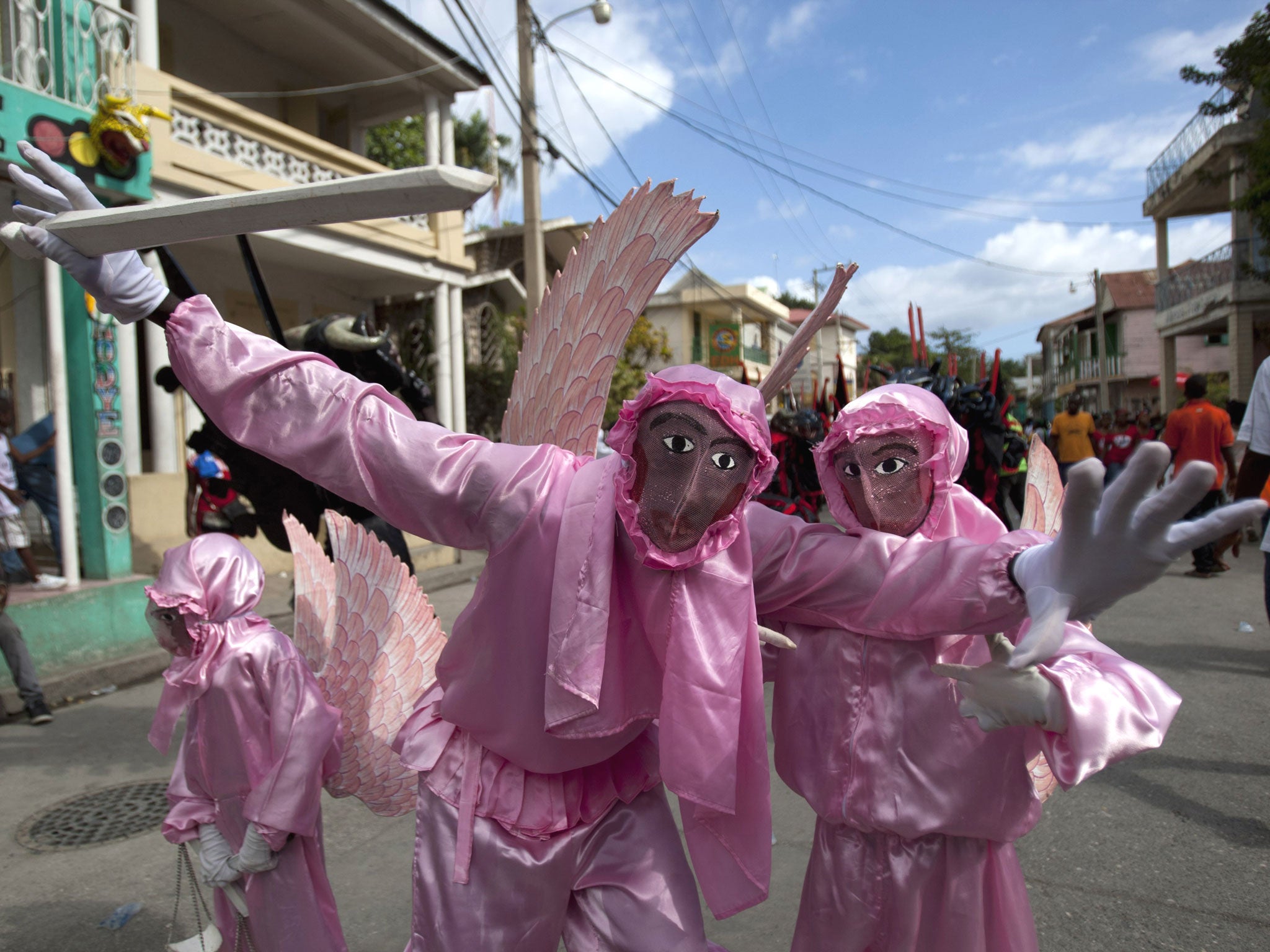 Revelers dressed as Archangel St. Michael dance during Carnival celebrations in Jacmel. The Carnival spirit took hold as Jacmel's annual parade snaked through the downtown of this coastal town revered among Haitians for its artists and artisans
