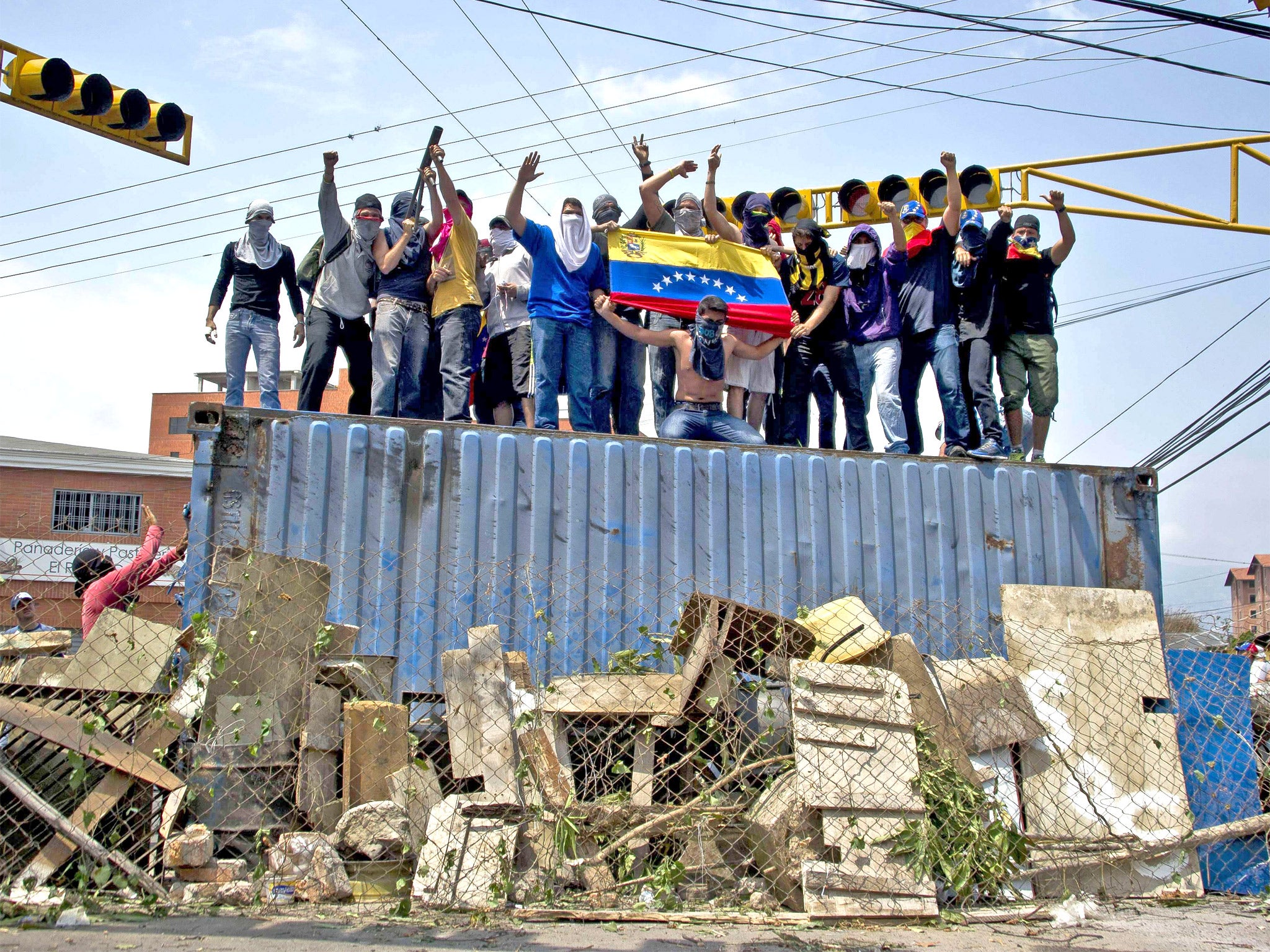 Protesters stand atop a roadblock in San Cristobal, western Venezuela, risking clashes with ‘Chavistas’
