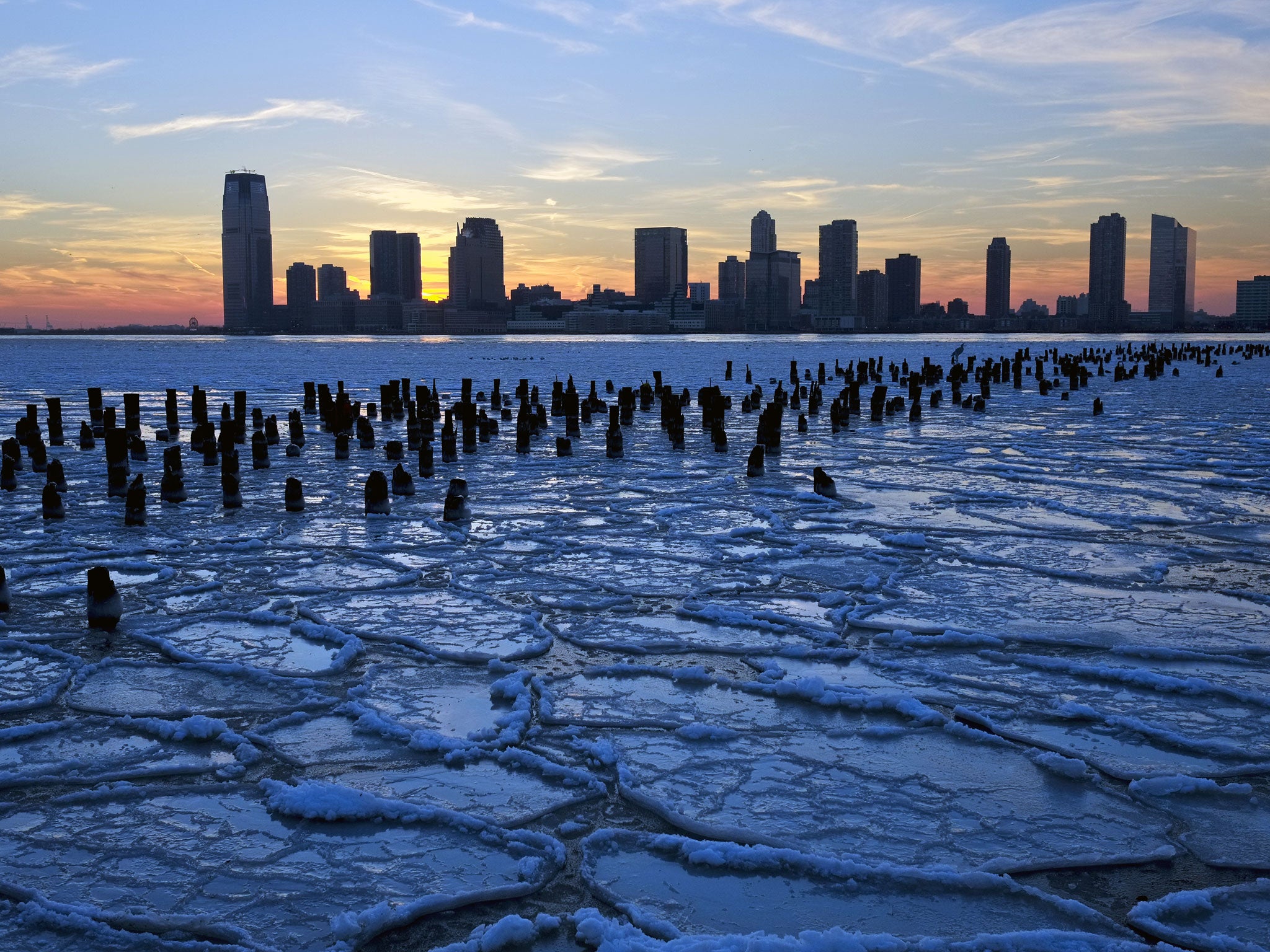 Ice floes fill the Hudson River as the New Jersey waterfront is seen during sunset on 9 January, in New York City.