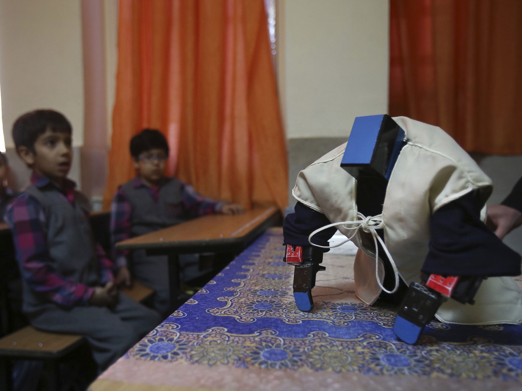 Veldan, a humanoid praying robot which is built by Iranian schoolteacher Akbar Rezaie, performs morning prayer in front of Alborz elementary school boys