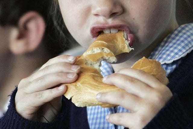 A child eating a bagel at a breakfast club.