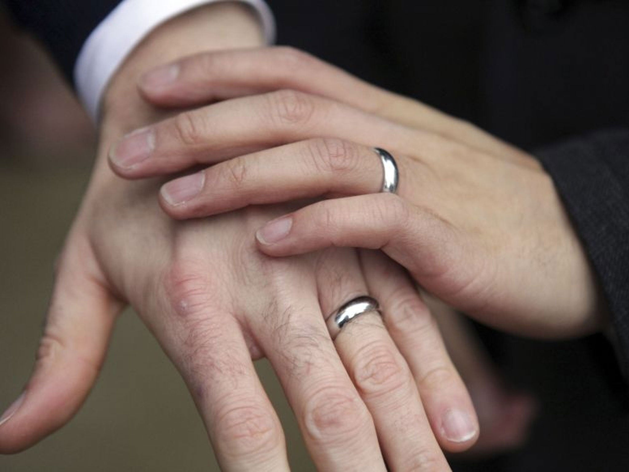 A same-sex couple show their rings after getting married.