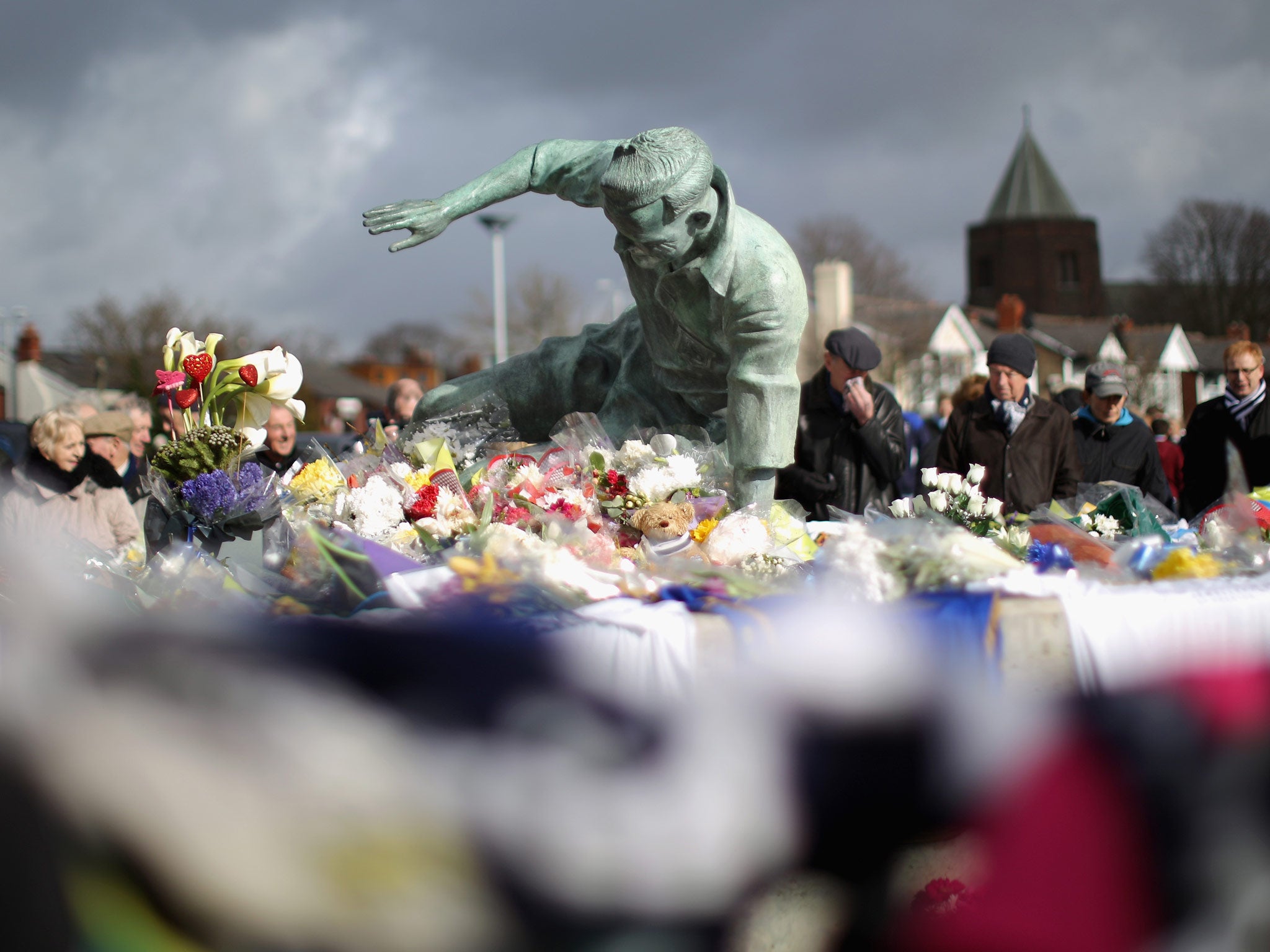 Flowers and tributes adorn the statue of Sir Tom Finney at Deepdale Stadium