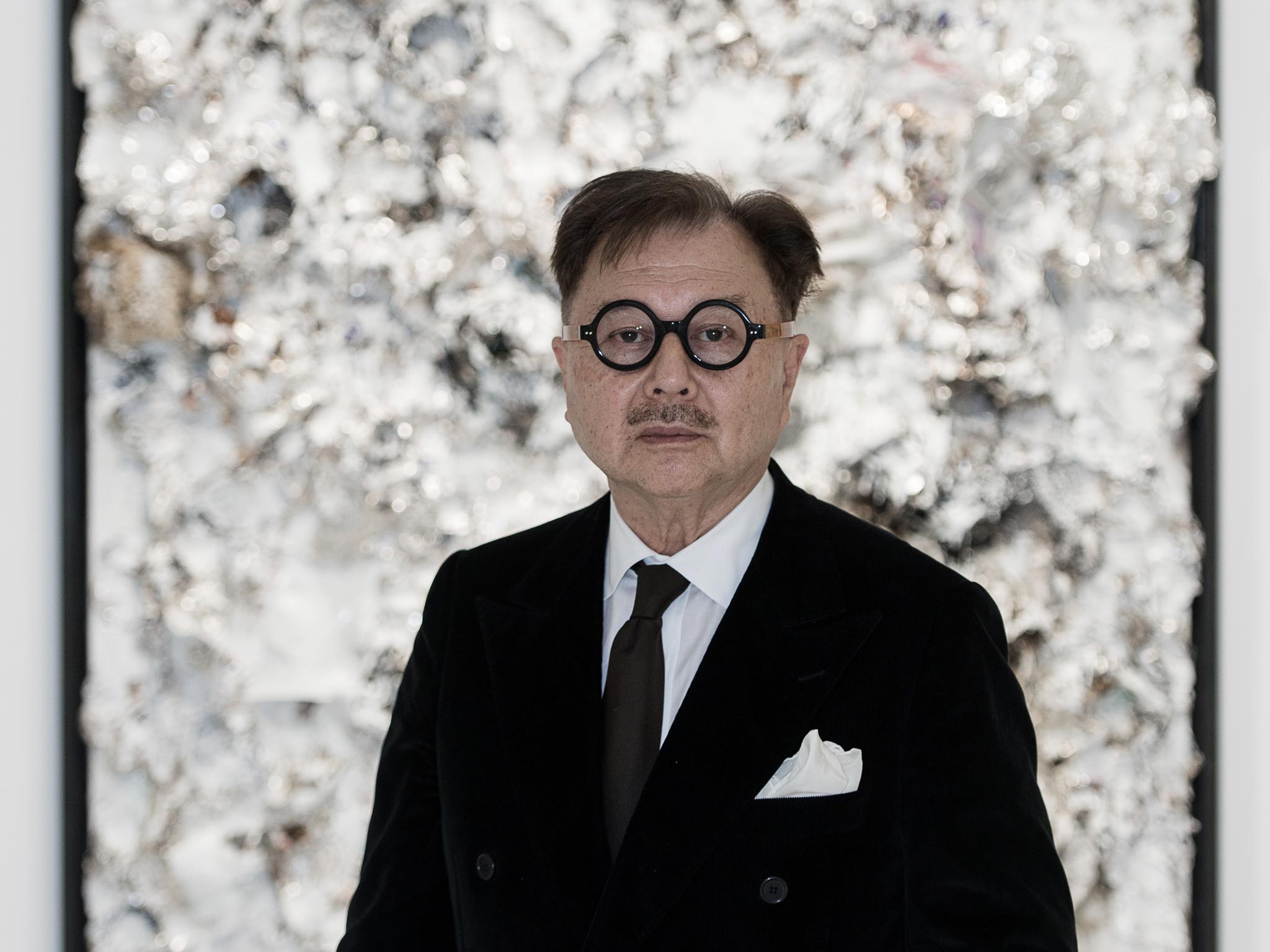 Michael Chow poses in front of his artworks