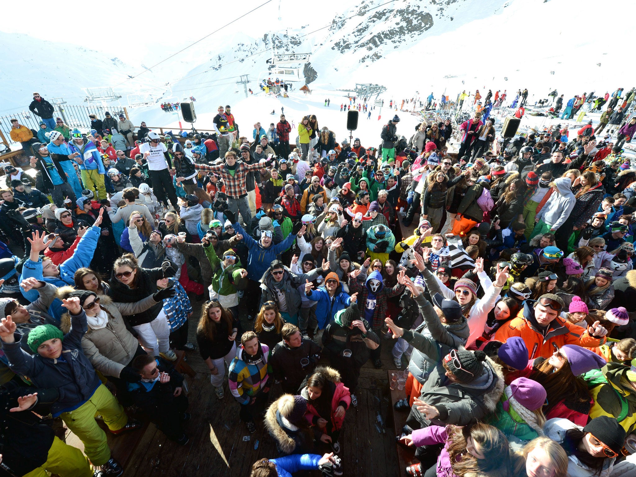 People drink and dance on an outdoor dance floor on the French Alps.