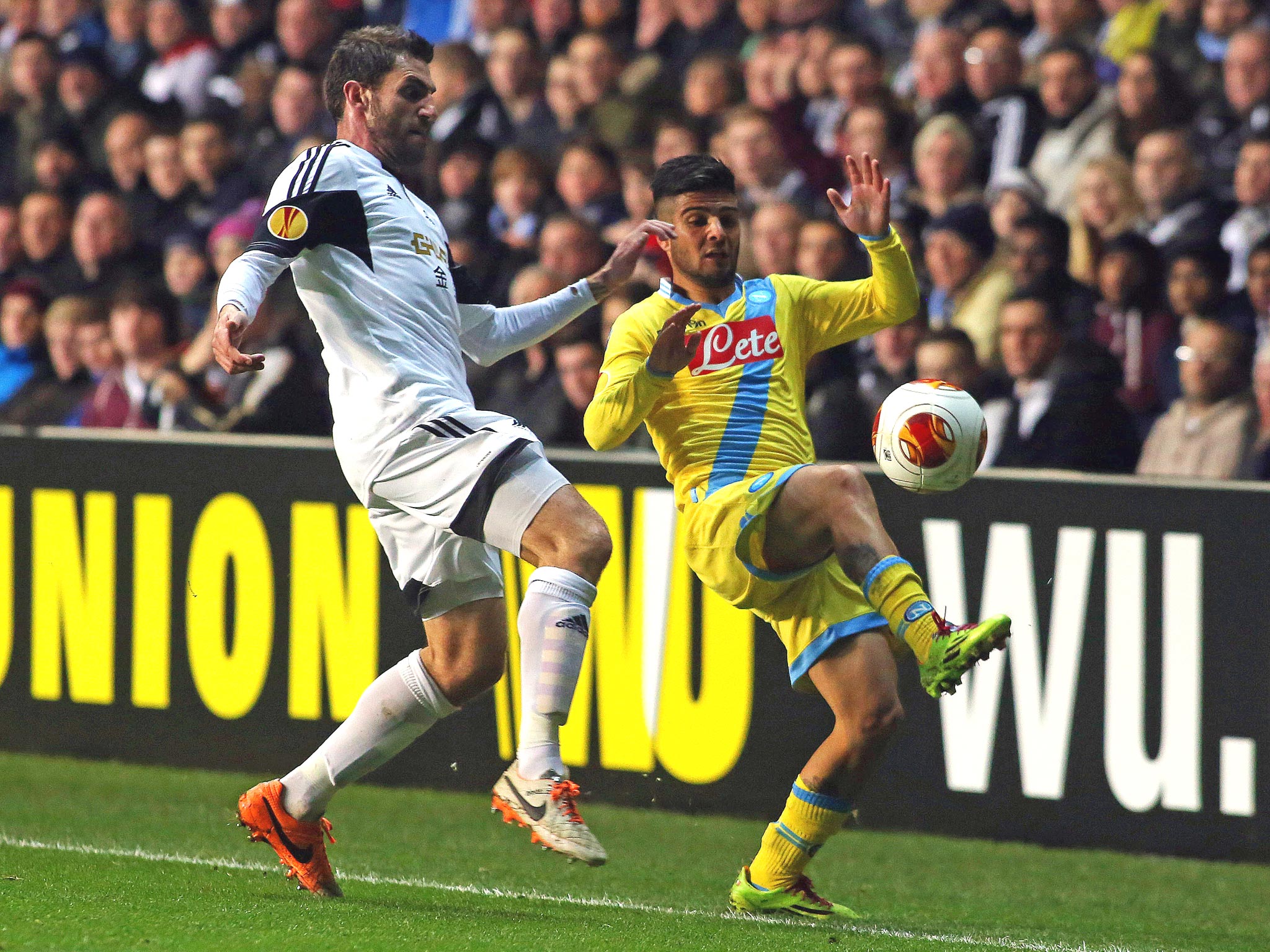 Swansea City's Spanish defender Angel Rangel (L) challenges Napoli's Italian forward Lorenzo Insigne (R) for the ball