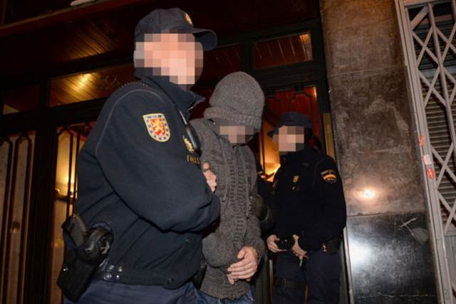 Officers from City of London Police and their Spanish counterparts from the Policia Nacional remove a suspect after raiding a business property in Barcelona