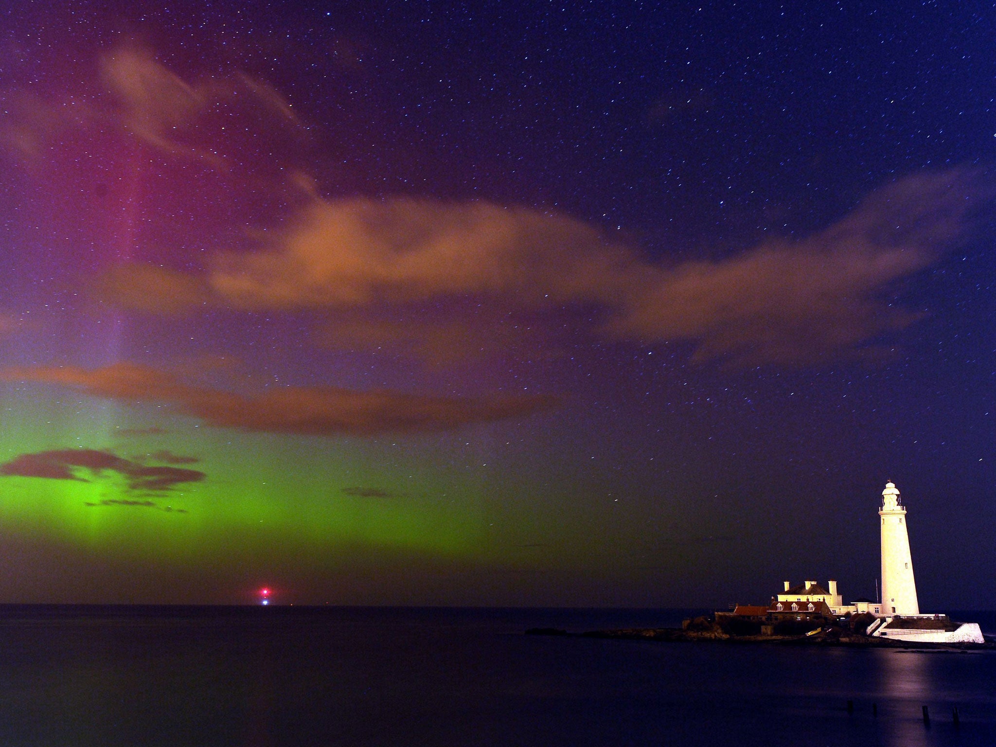 The aurora borealis, or the northern lights as they are commonly known, at St. Mary's Lighthouse and Visitor Centre, Whitley Bay, North Tyneside