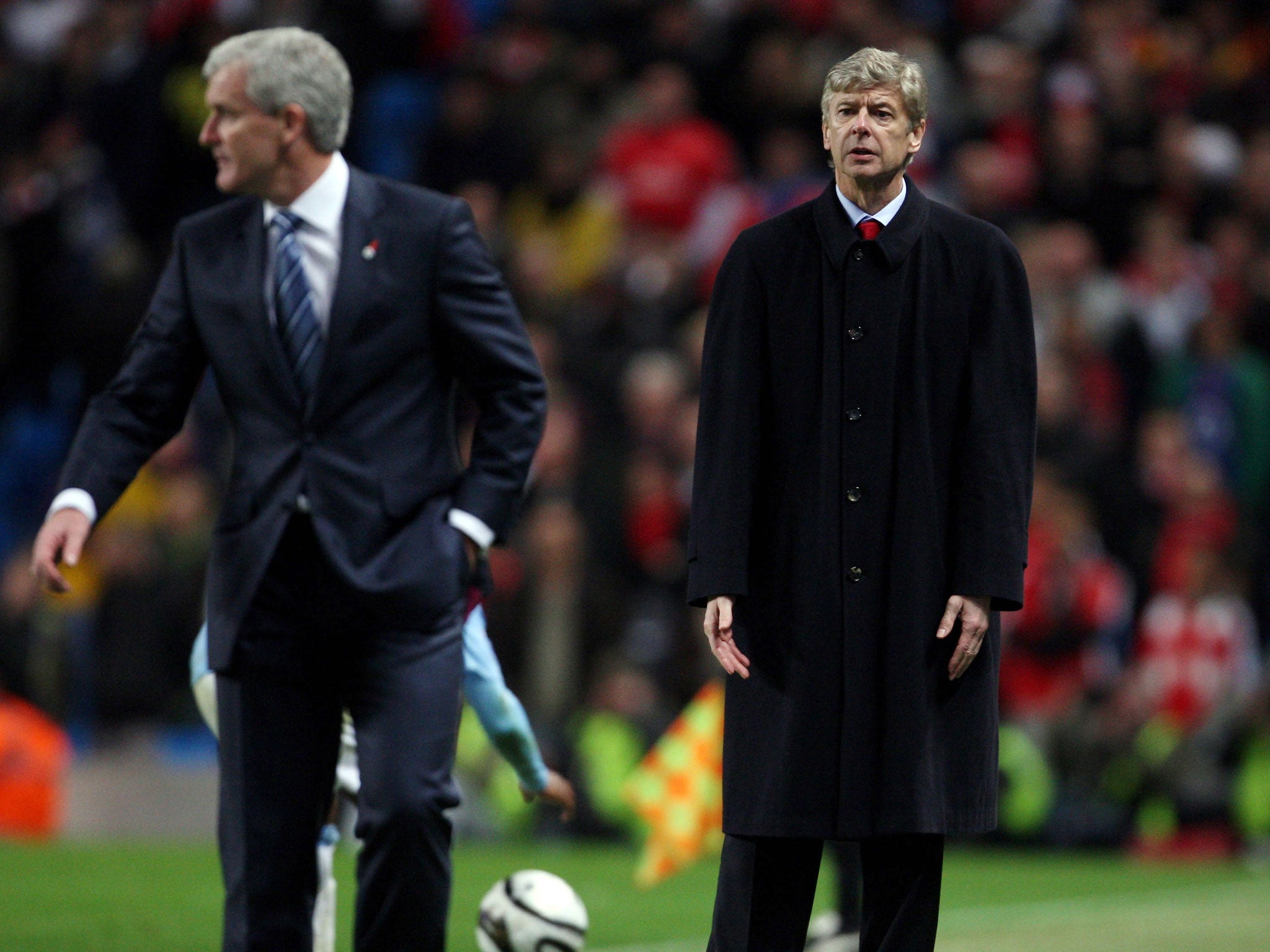 Manchester City manager Mark Hughes (left) and Arsene Wenger clash on the touchline in 2009