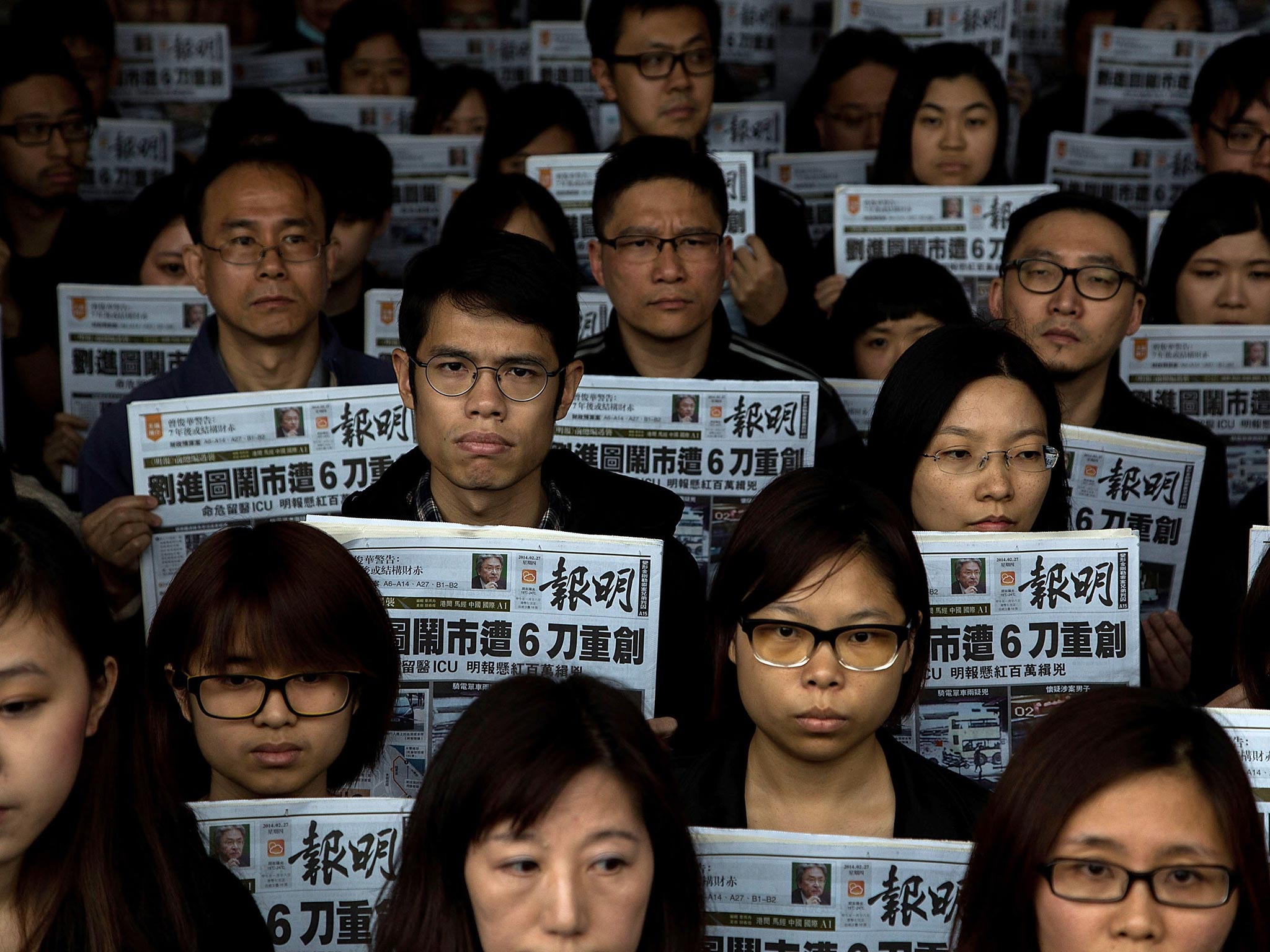 Staff members of Ming Pao hold its newspaper printed on 27 February in which former chief editor of Ming Pao kevin Lau Chun-to was stabbed