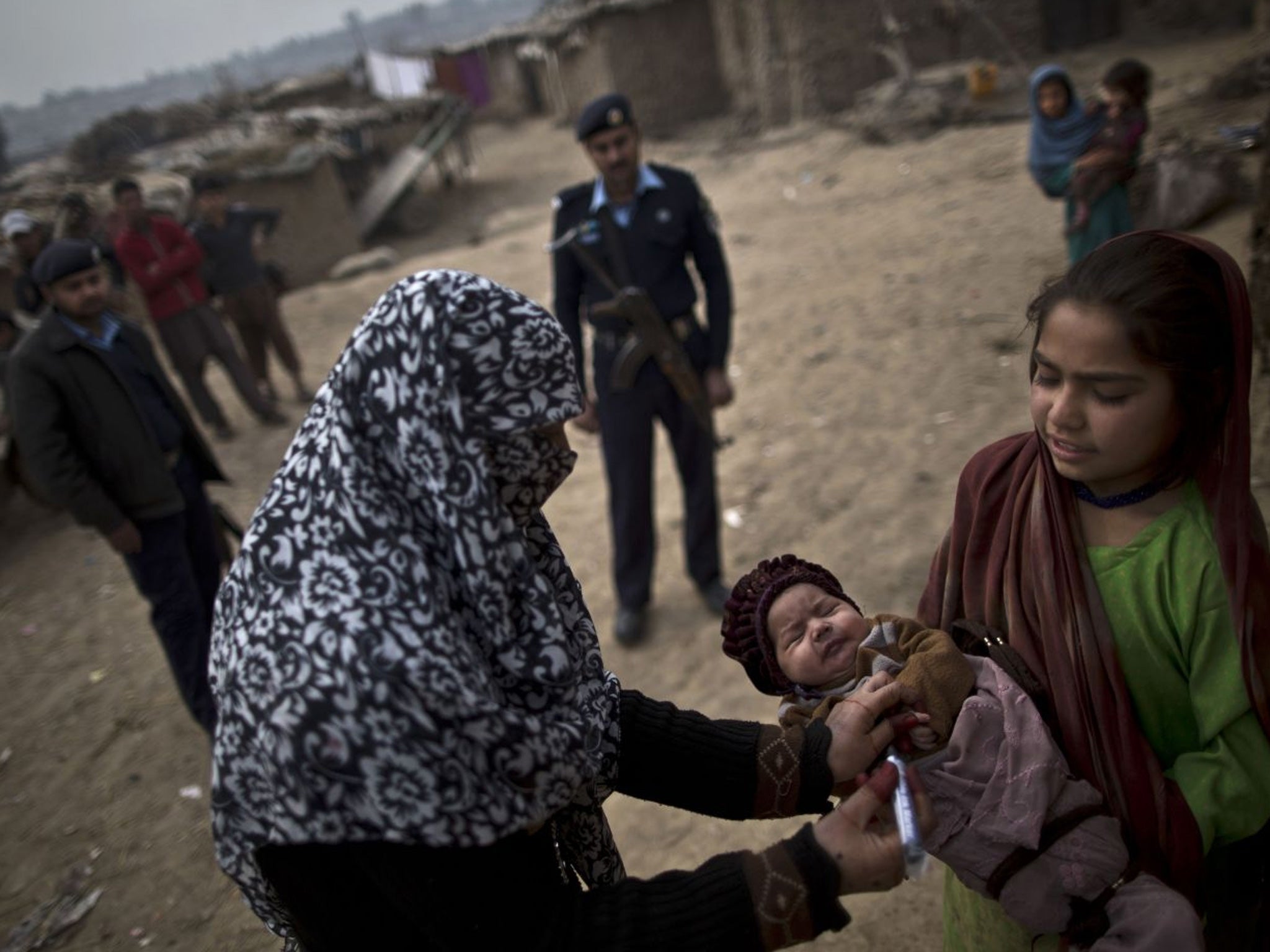A Pakistani health worker marks the finger of a child after it was given a polio vaccine
