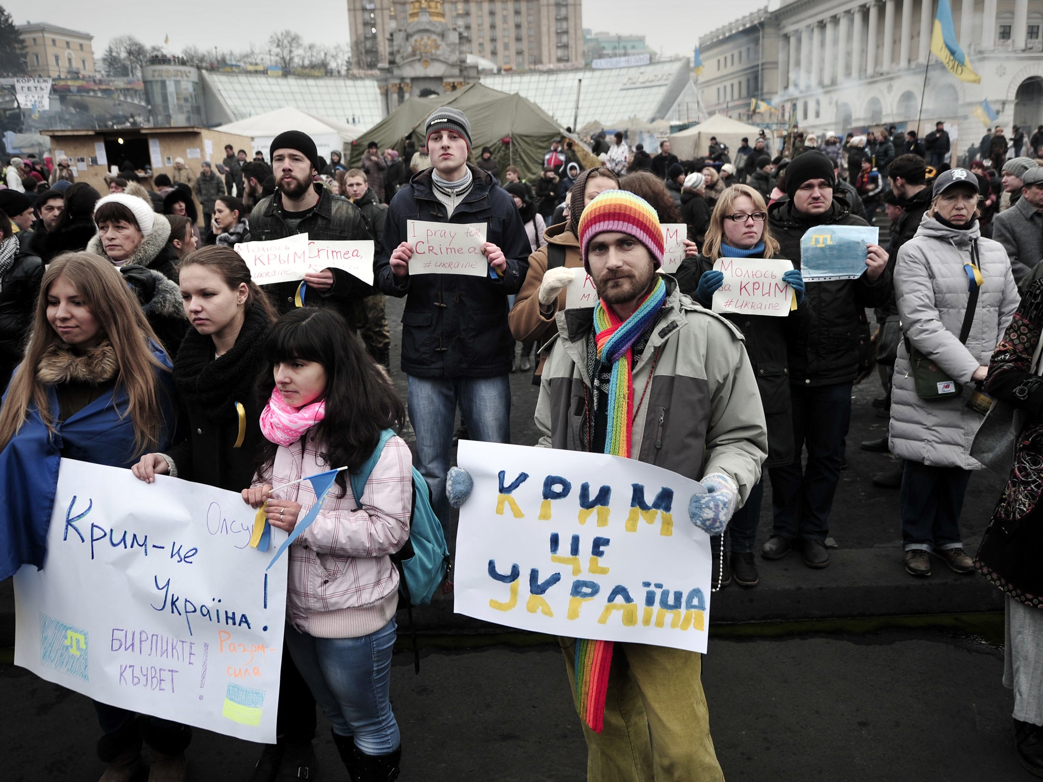 People hold placards reading 'Crimea is Ukraine' and 'I pray for Crimea' during a rally on Independence square in central Kiev on March 1, 2014. Ukraine accused Russia on March 1, 2014