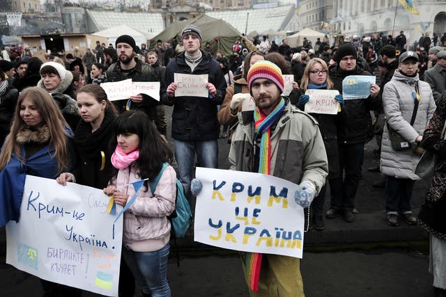 People hold placards reading 'Crimea is Ukraine' and 'I pray for Crimea' during a rally on Independence square in central Kiev on March 1, 2014. Ukraine accused Russia on March 1, 2014