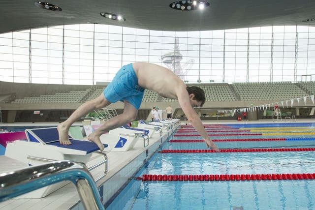 Independent reporter Jamie Merrill dives into the pool at the London Aquatic Centre